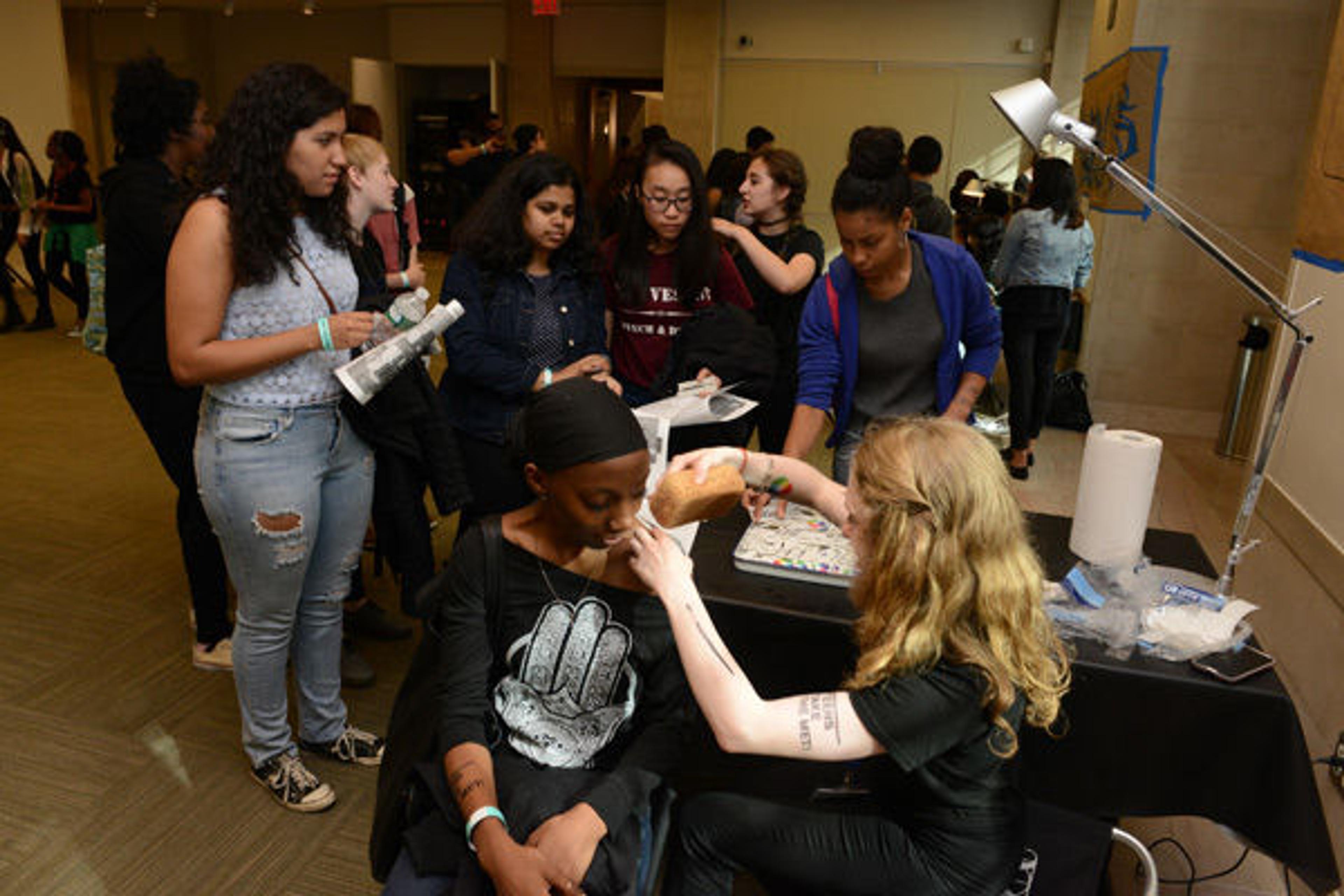 The temporary tattoo parlor. A Met teen watches as their temporary tattoo is applied.