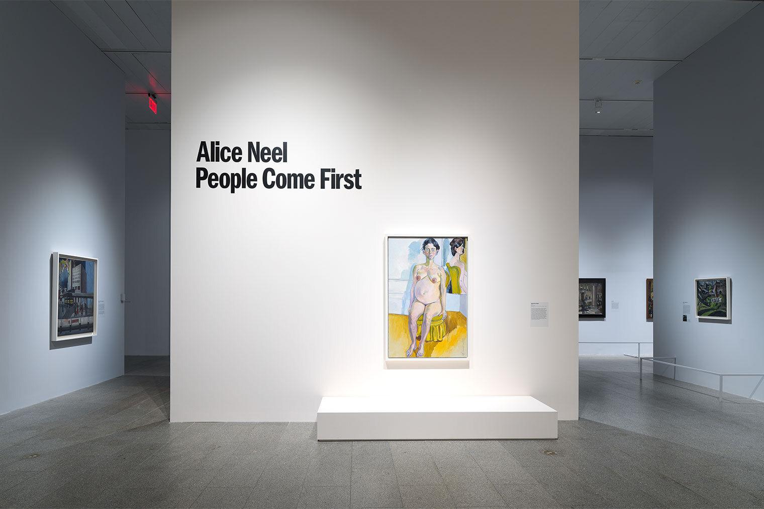 Several paintings are hung in a gallery