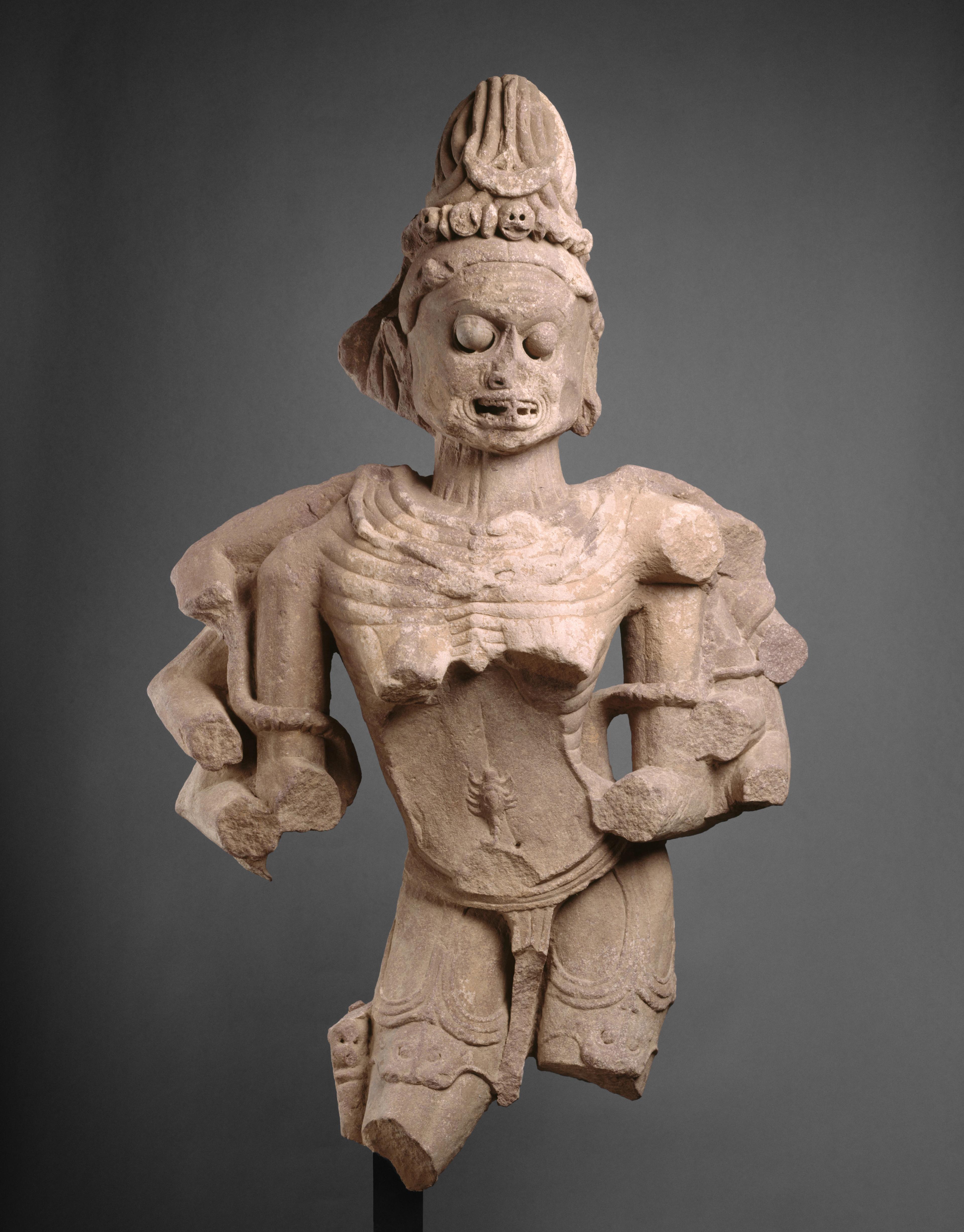 Skeletal, warrior-like figure carved in stone.