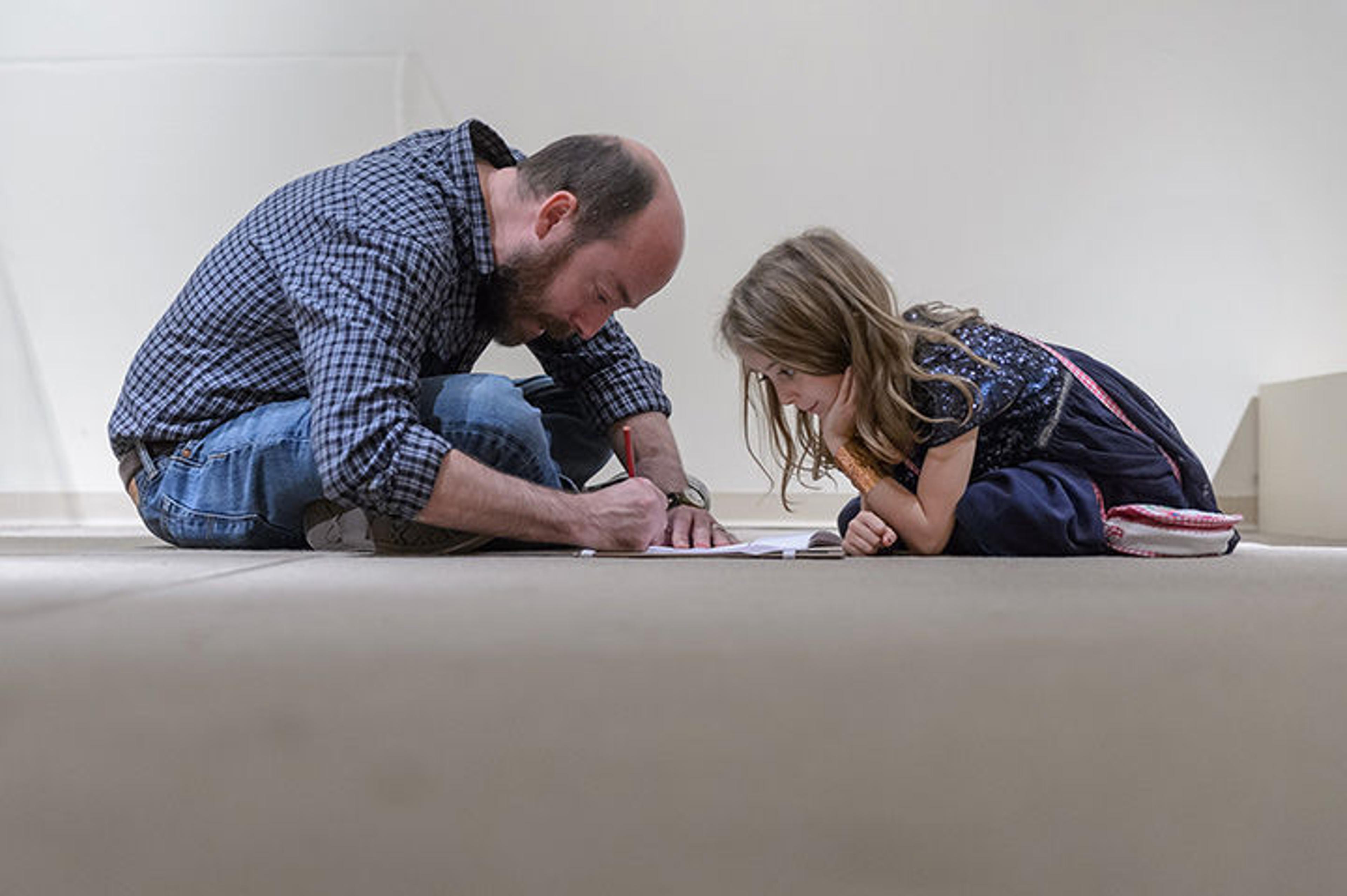 Father and daughter sketching in gallery