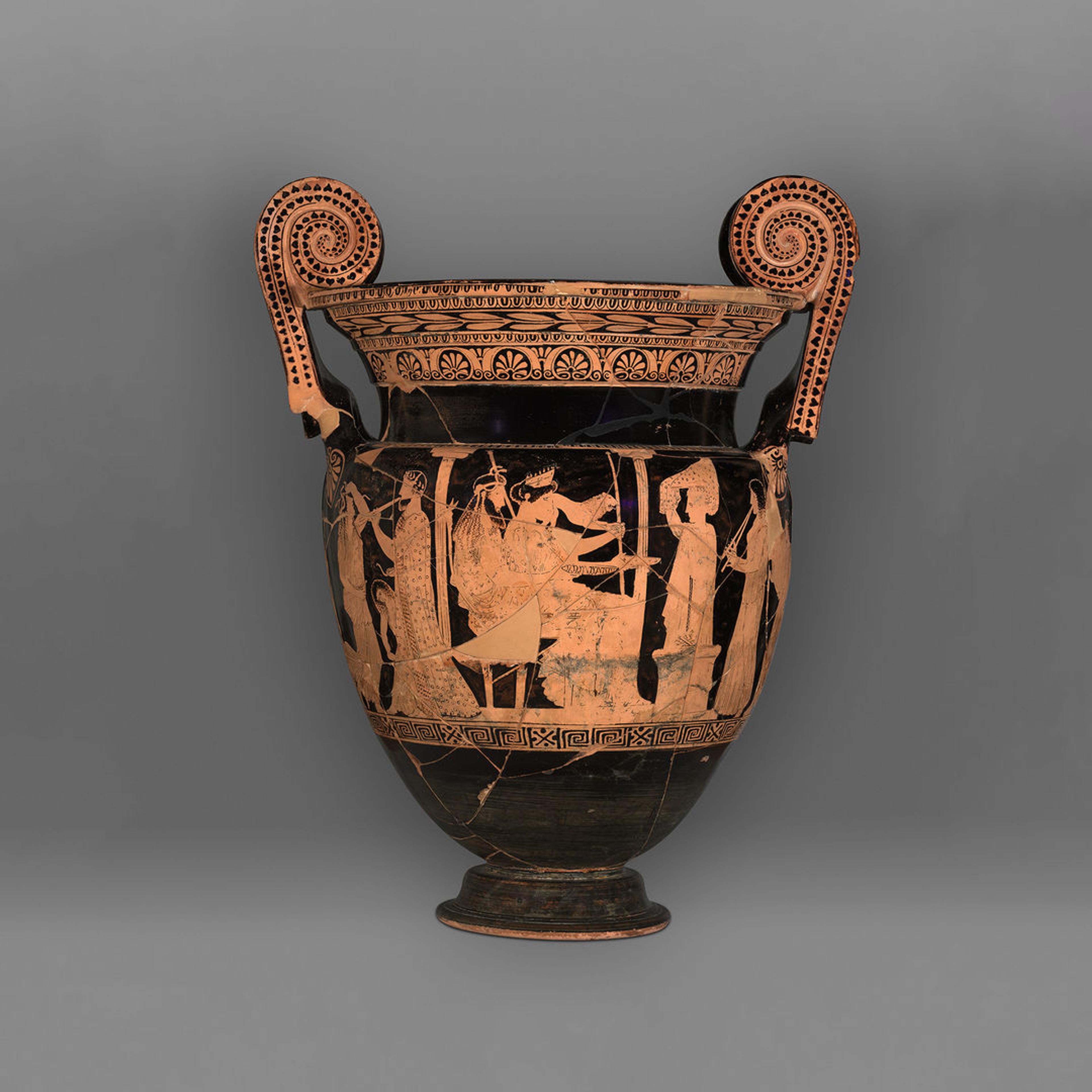 Detail image of the volute-krater that shows the divine couple seated between two columns, flanked by a priestess and figures playing instruments.