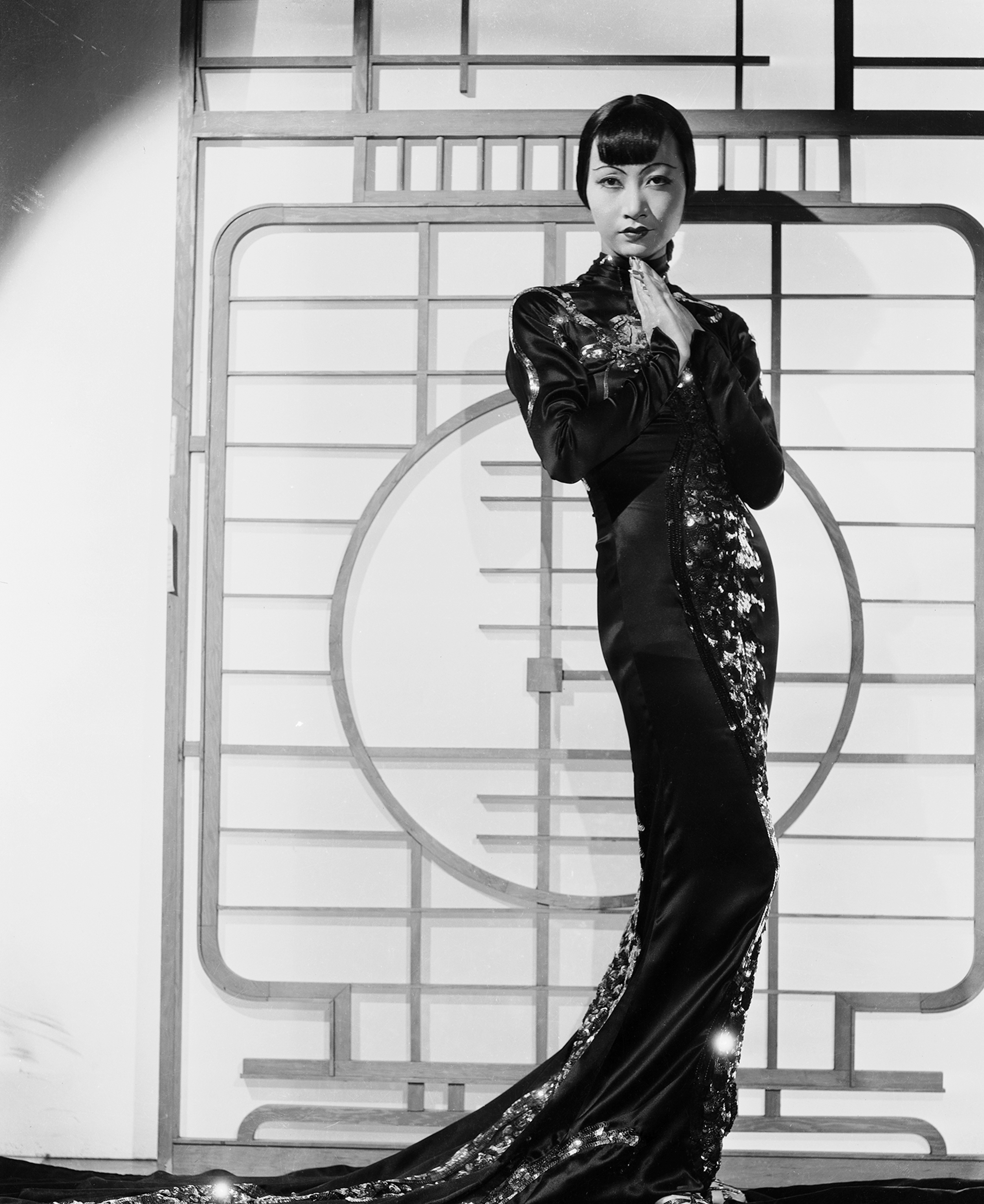 Black and white photo of woman posting where wearing a tradition Asian style dress.