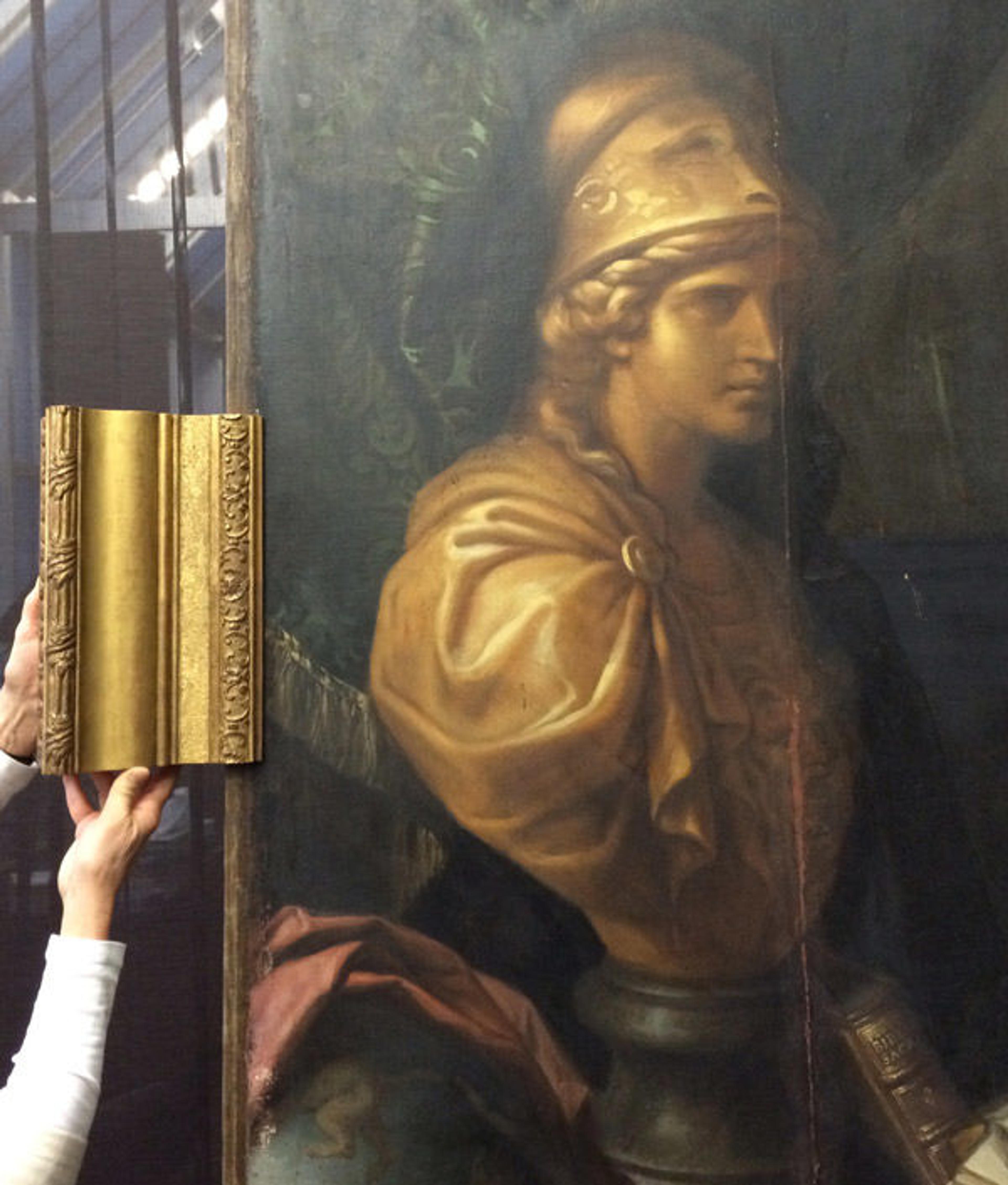 Person holding frame sample against the painting