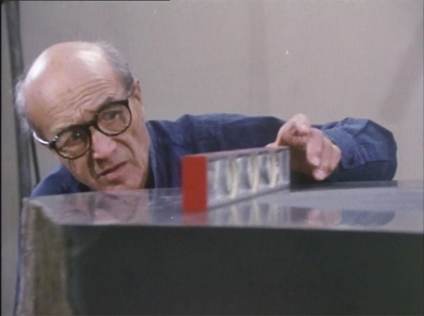 An older man measures the flatness of a large stone