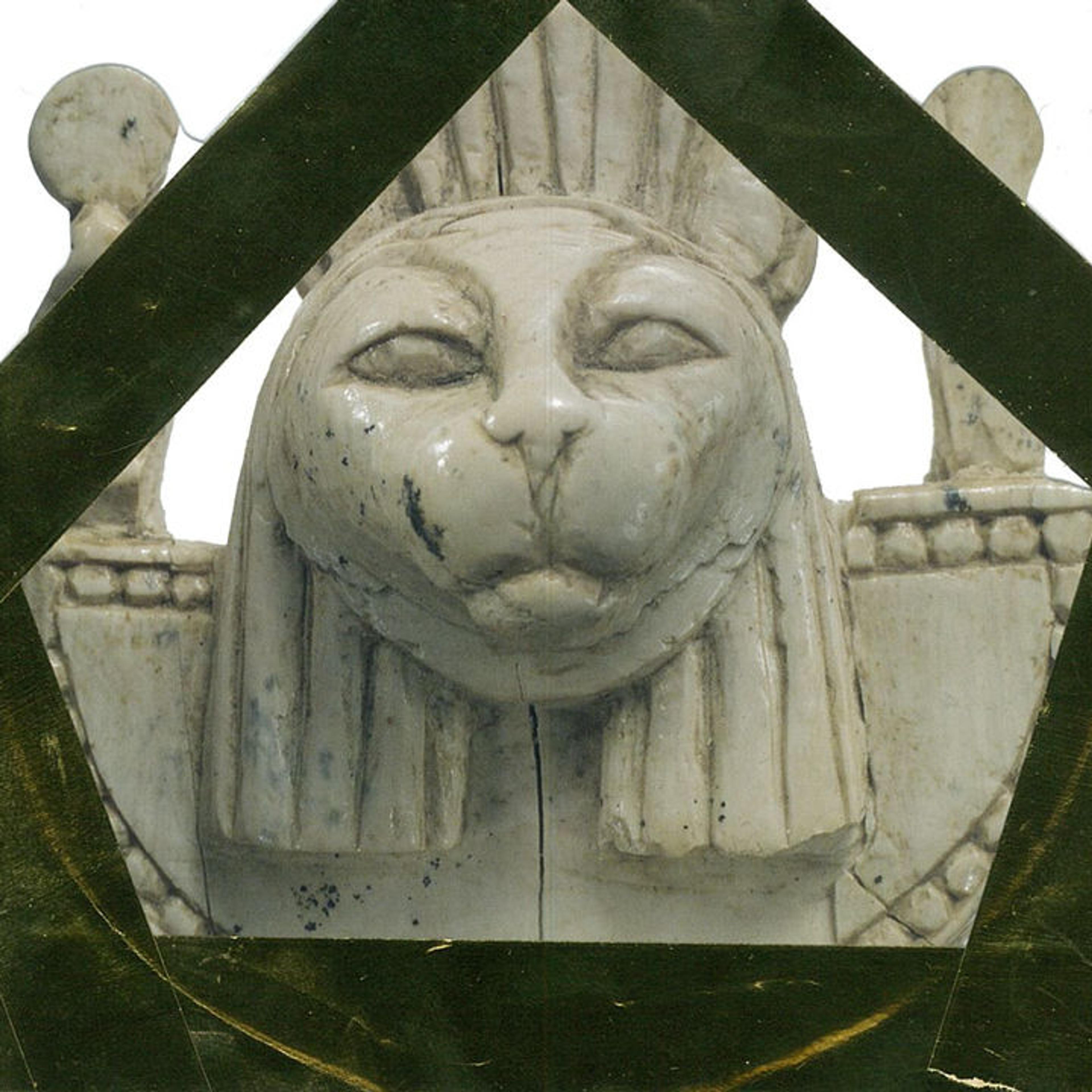 Picture of a kid's love letter to an ivory carving with a sculpted cat head wearing a collar. The kid has decorated the love note with gold tape.