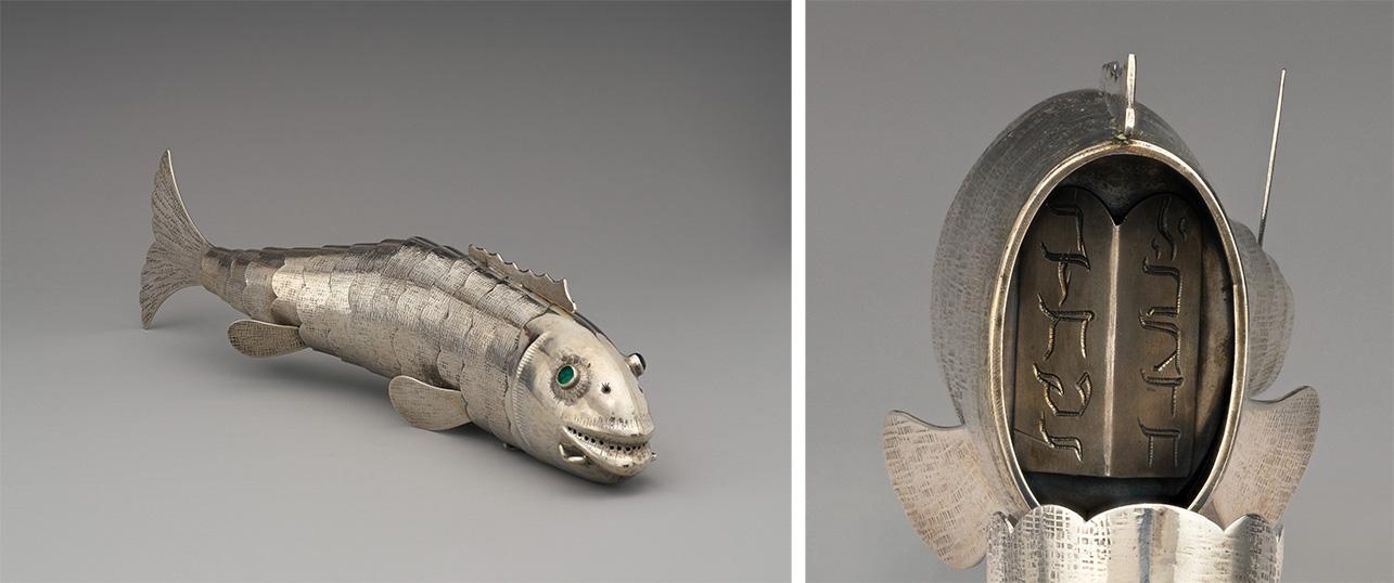 A detailed silver fish sculpture with green eyes, textured scales, and an articulated body.