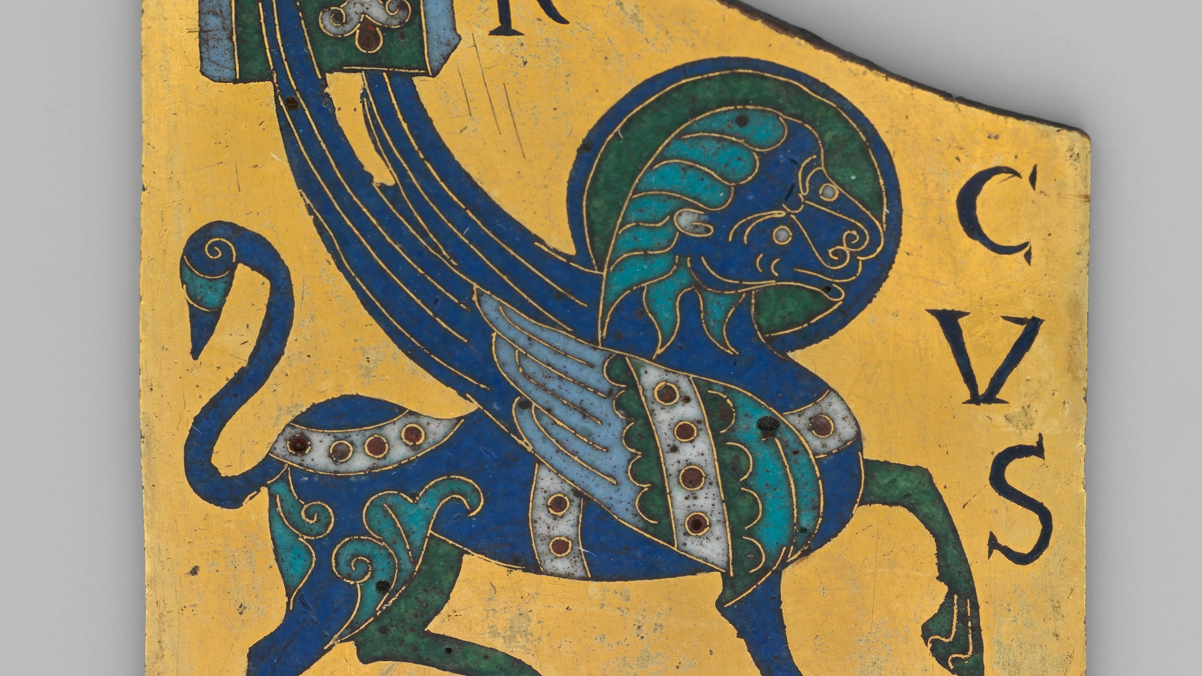 An ornate blue mythical creature with sweeping wings, curled tail, and patterned feathers fills a worn gold manuscript page beside dark decorative letters.