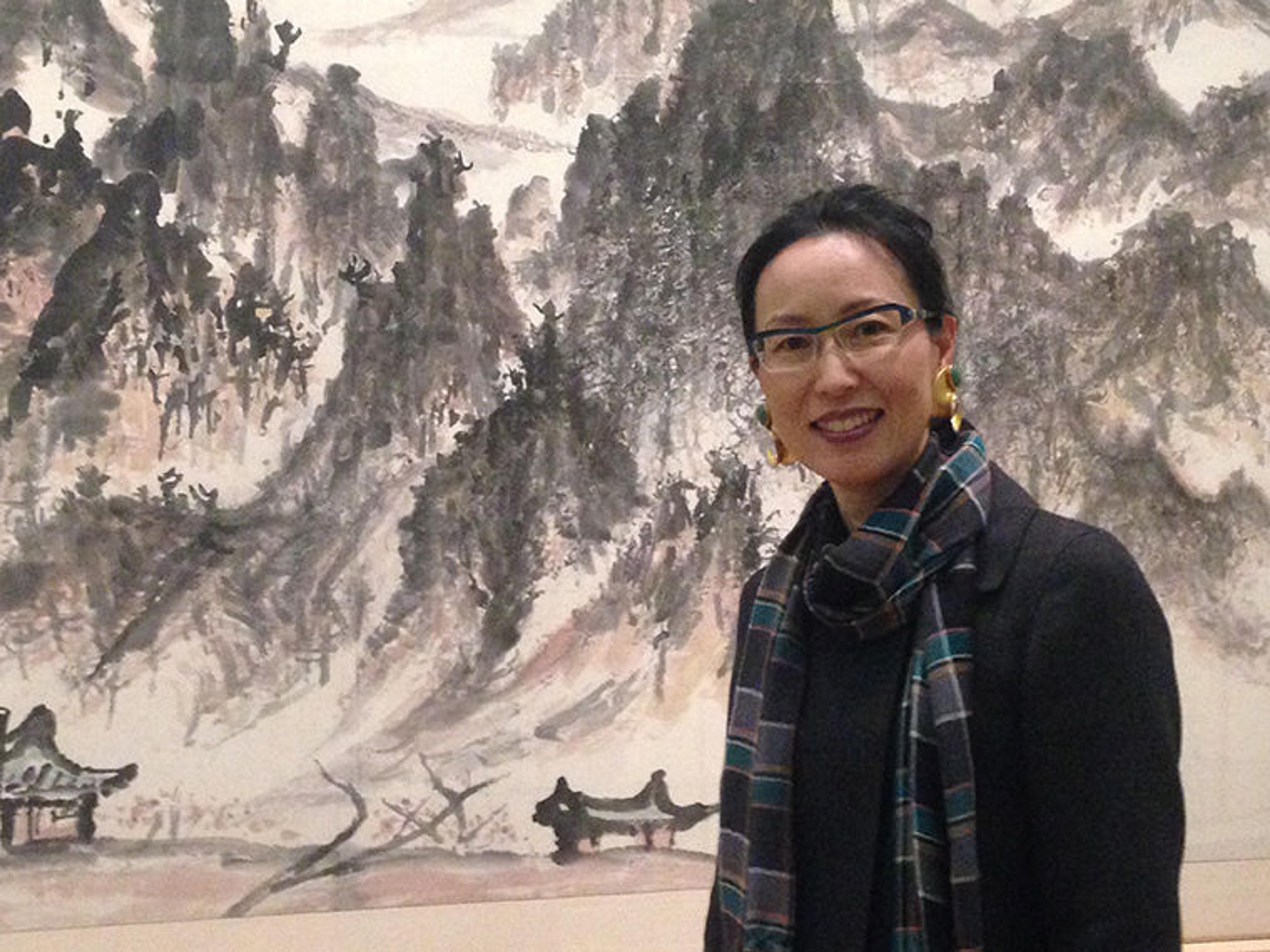 Curator Soyoung Lee in front of painting by Lee Ungno