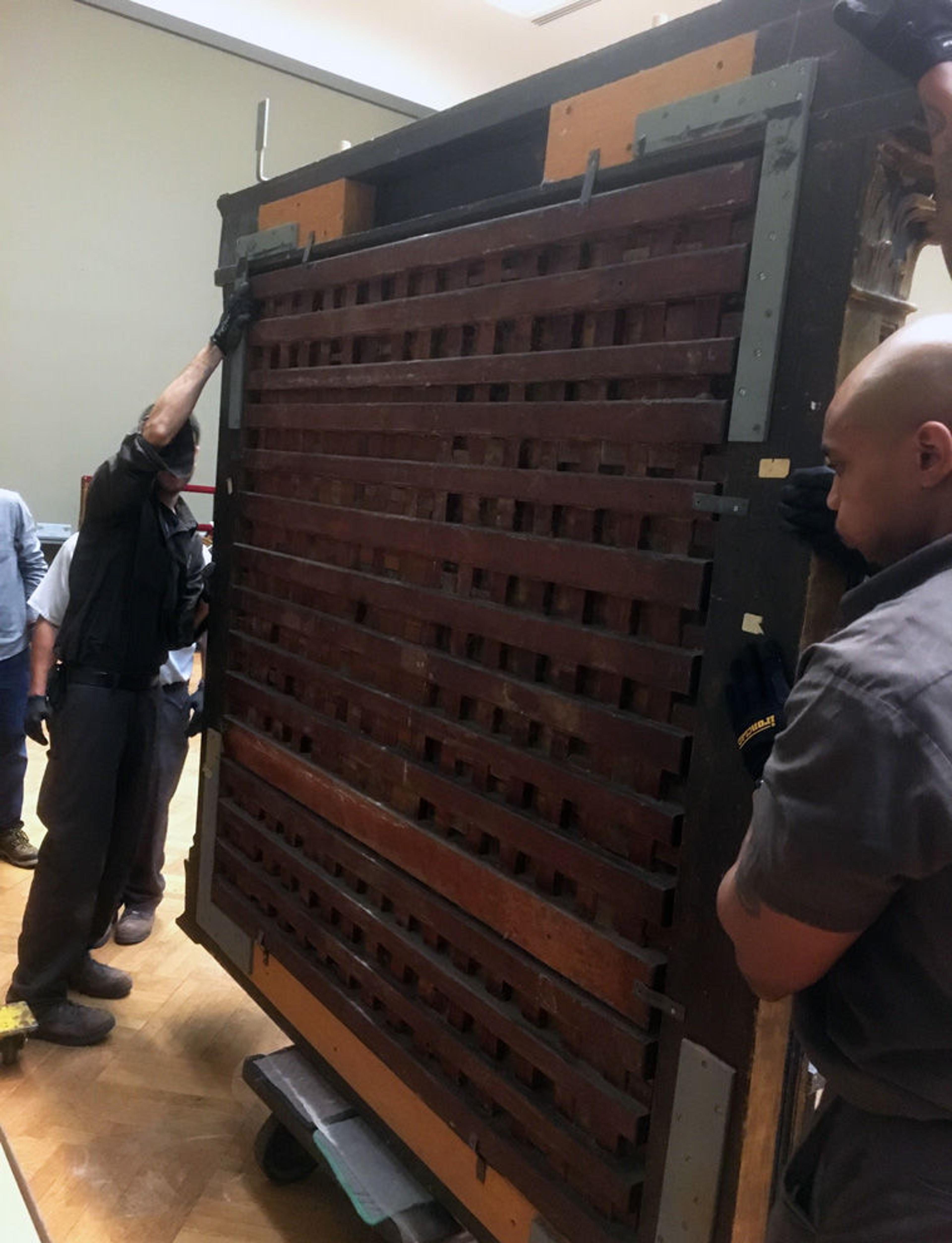 View of the back of an altarpiece by Raphael as it is moved in an art gallery