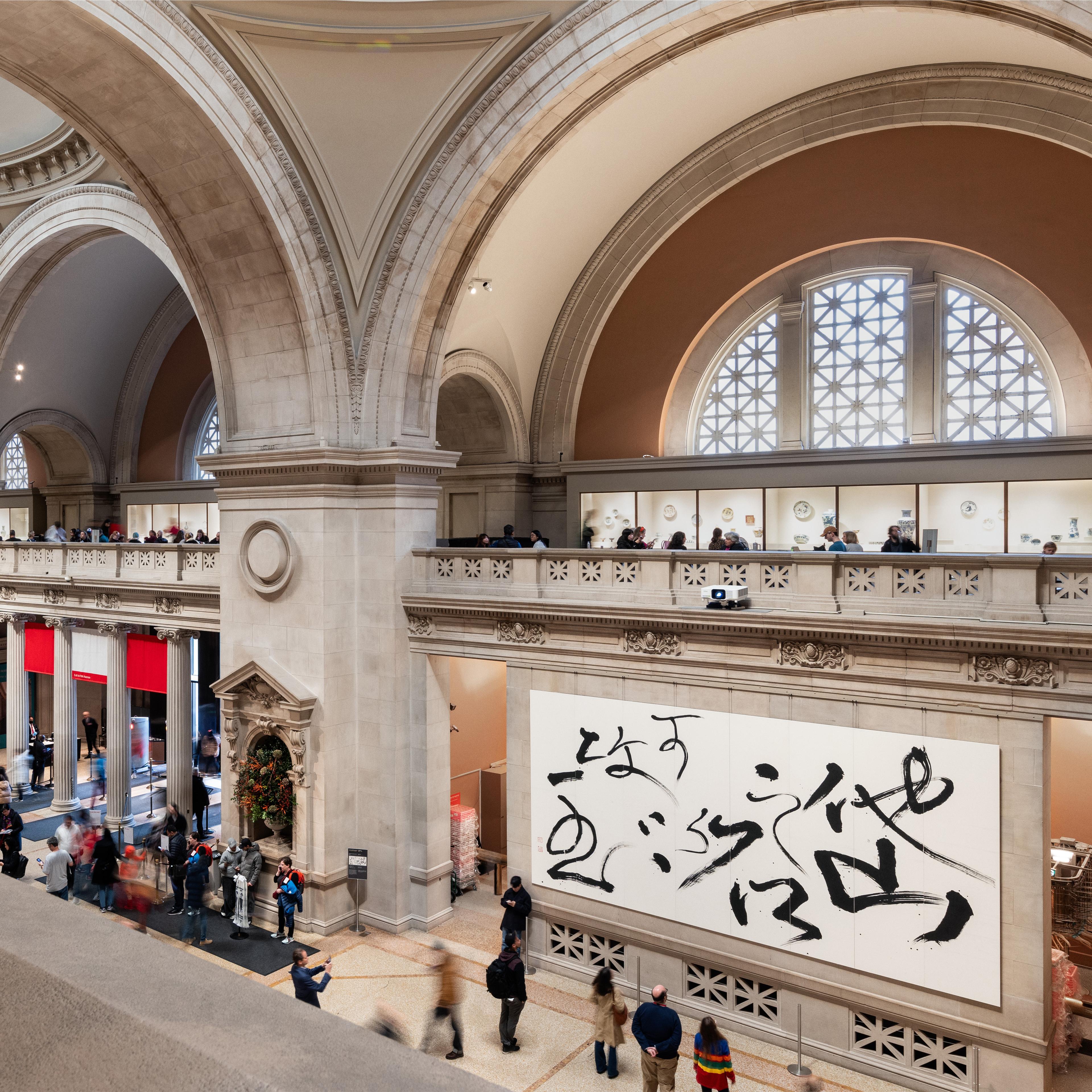 Photo image of The Great Hall of the Met, with hanging calligraphy paintings