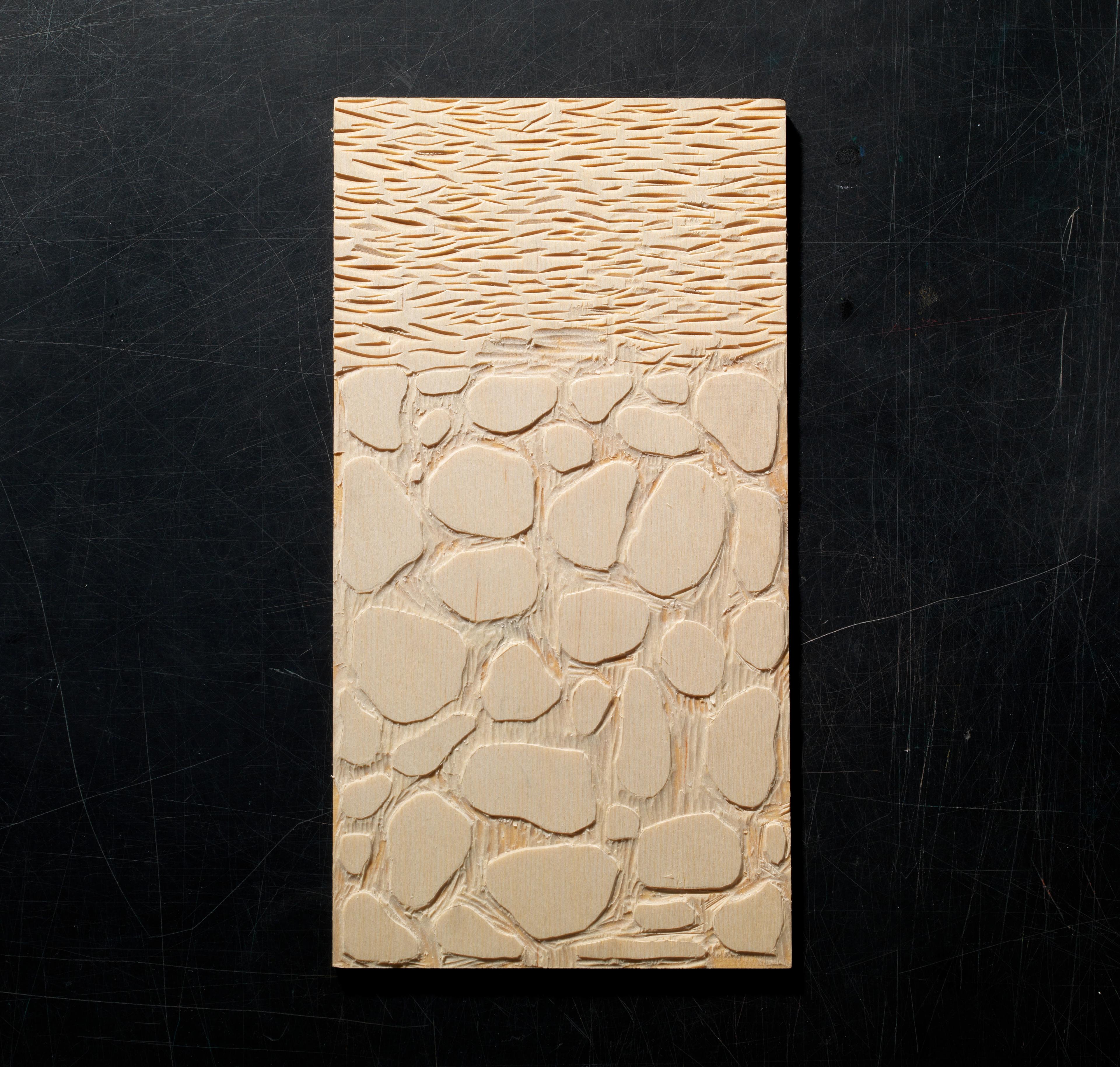 Image of a woodblock that has been cut into a design.