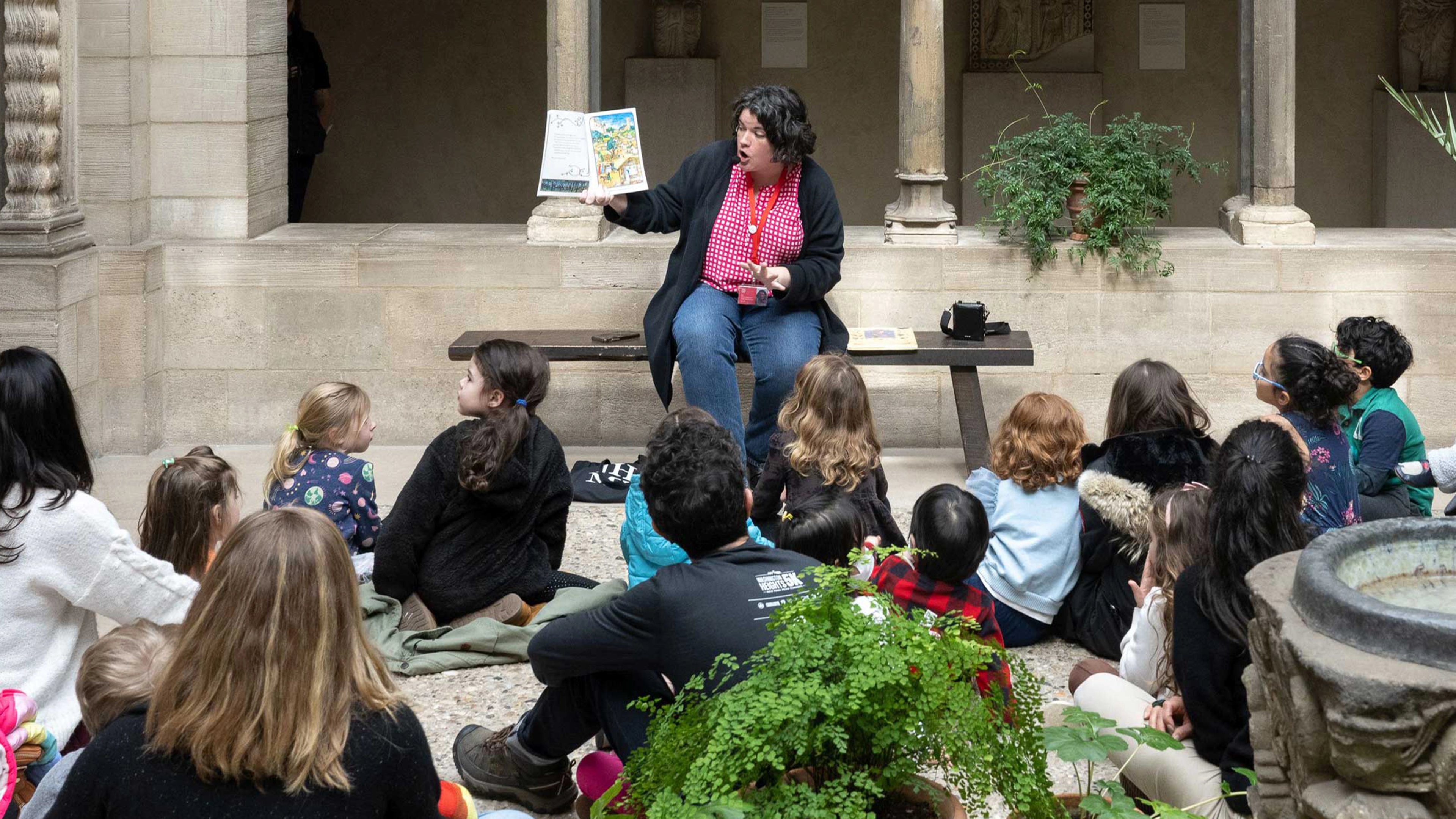 A guide reads a story to a group of children. Photo by Filip Wolak