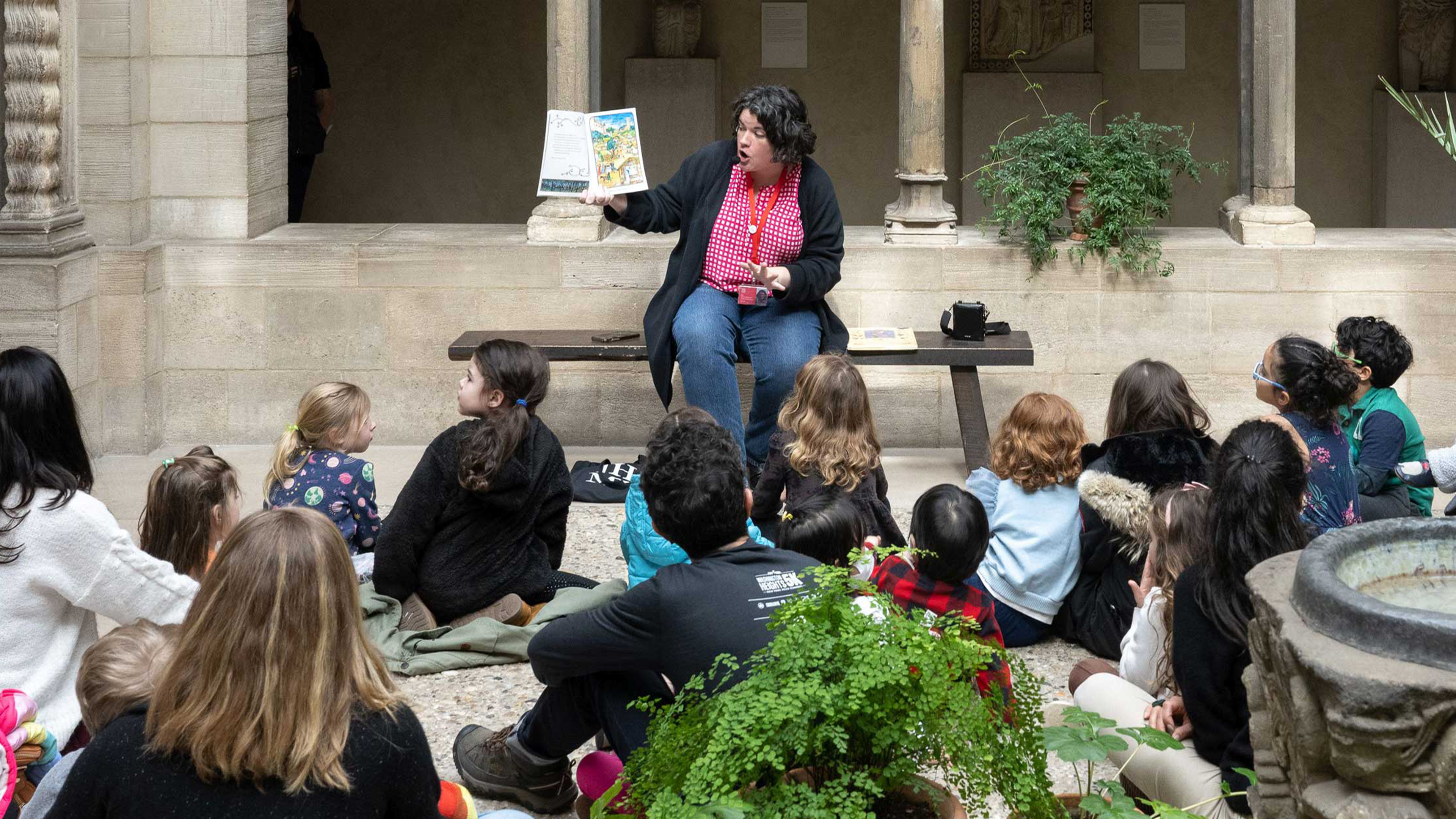 A guide reads a story to a group of children. Photo by Filip Wolak