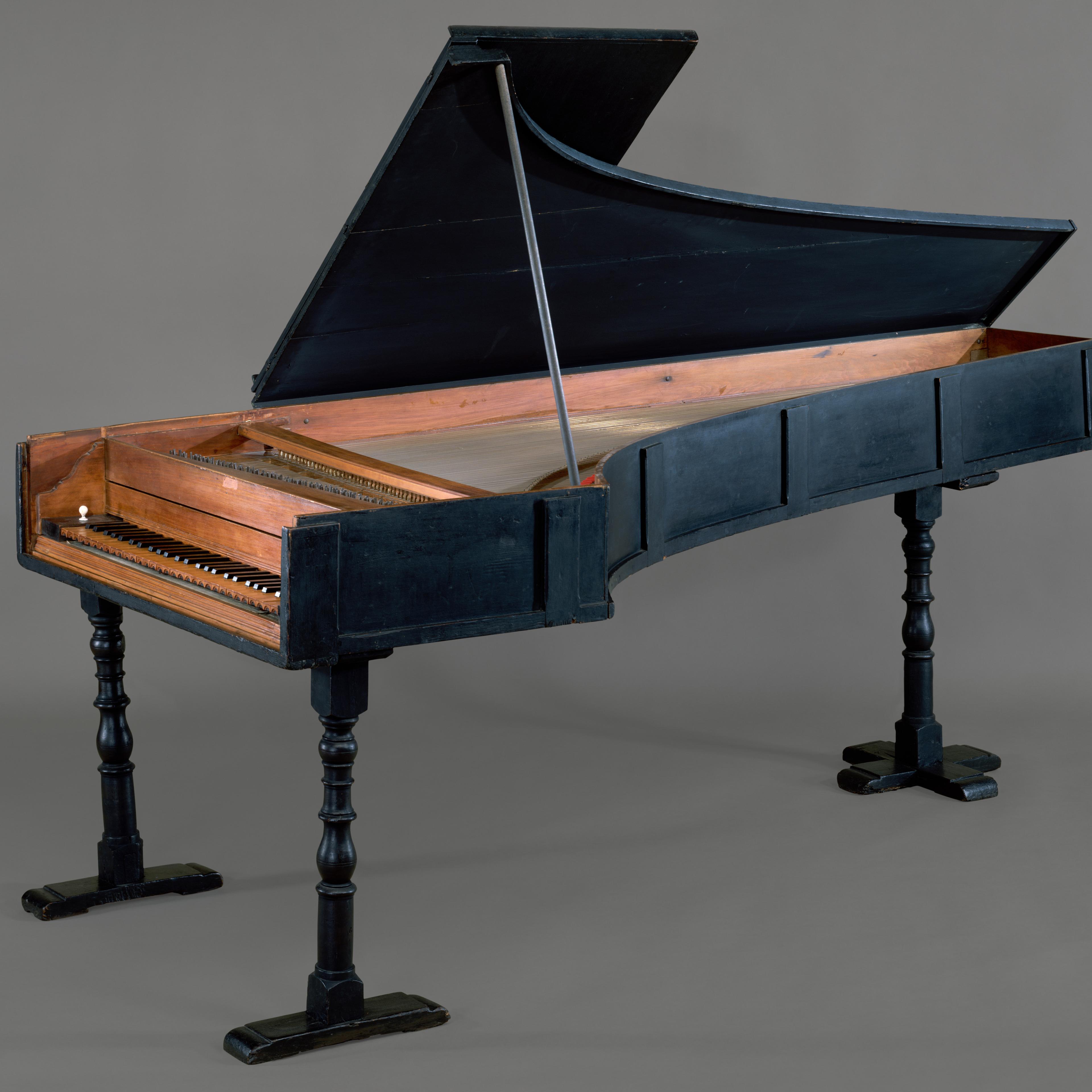 A seventeenth-century grand piano, made of cypress and boxwood, in front of a gray background