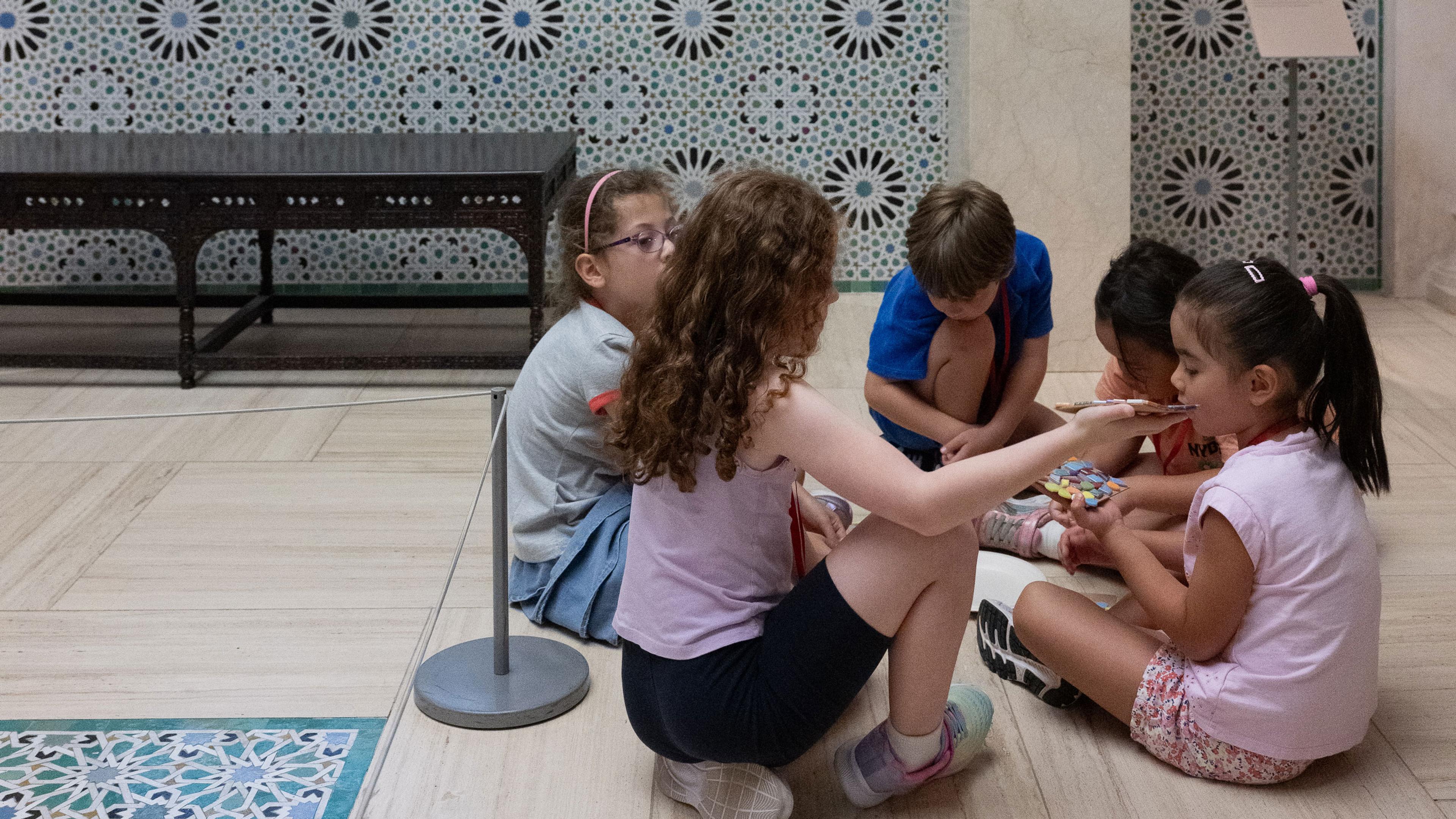young children sitting in a circle, doing arts and crafts