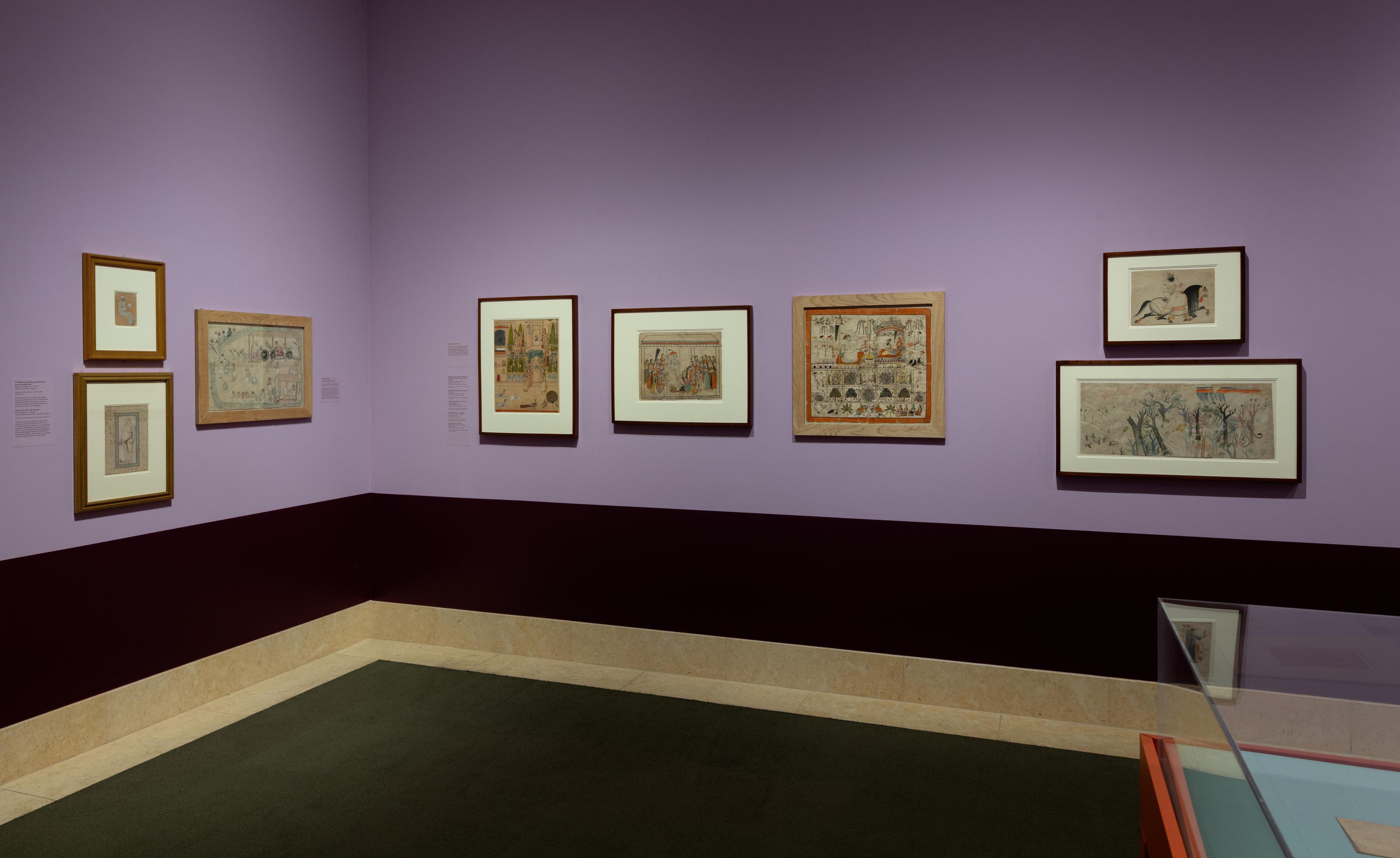 An art gallery room with purple walls displays framed historical paintings. The pieces are varied in size, and a glass display case is partially visible.