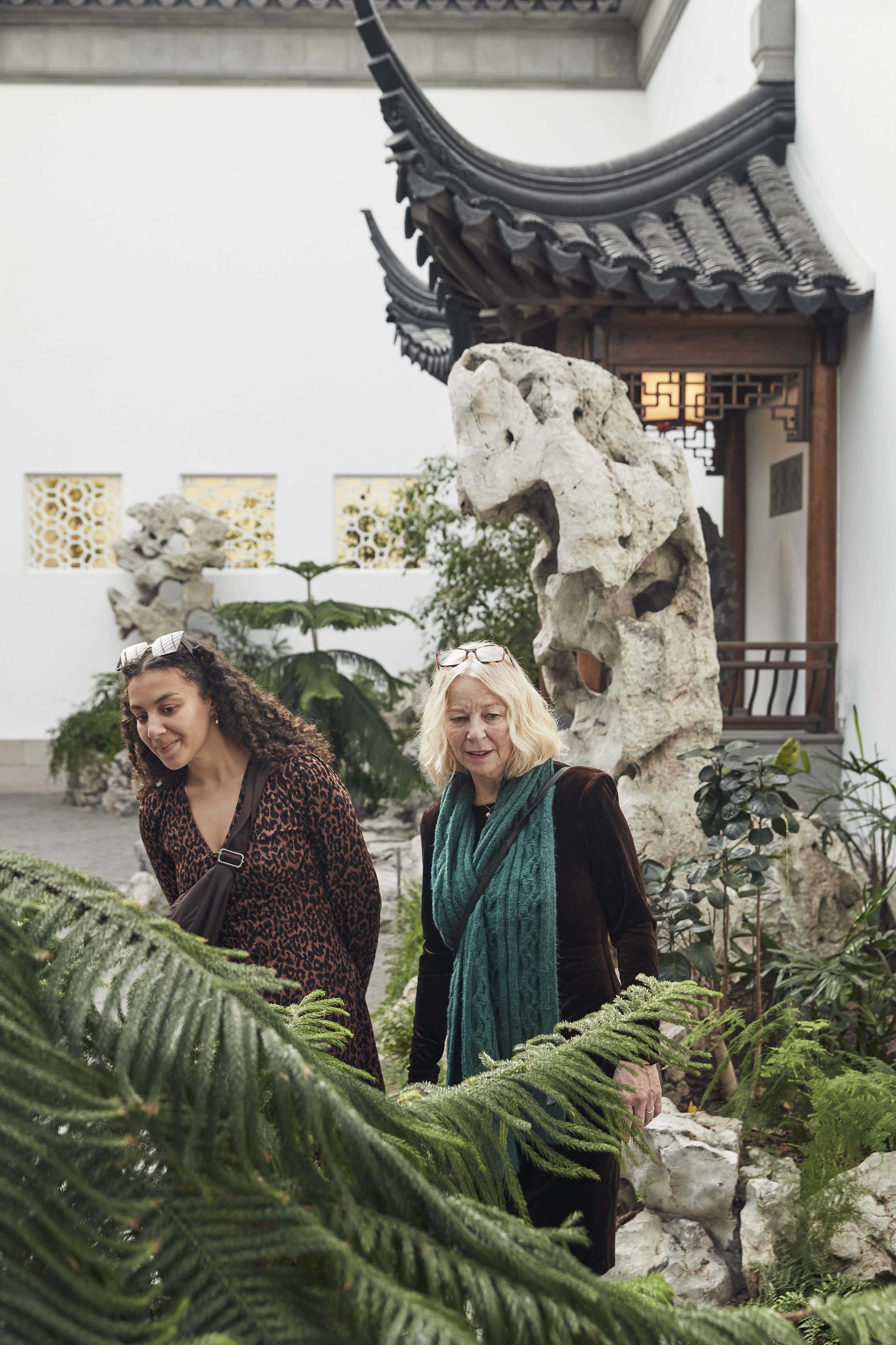 Two women look at their surroundings in The Met's Chinese Astor Court.