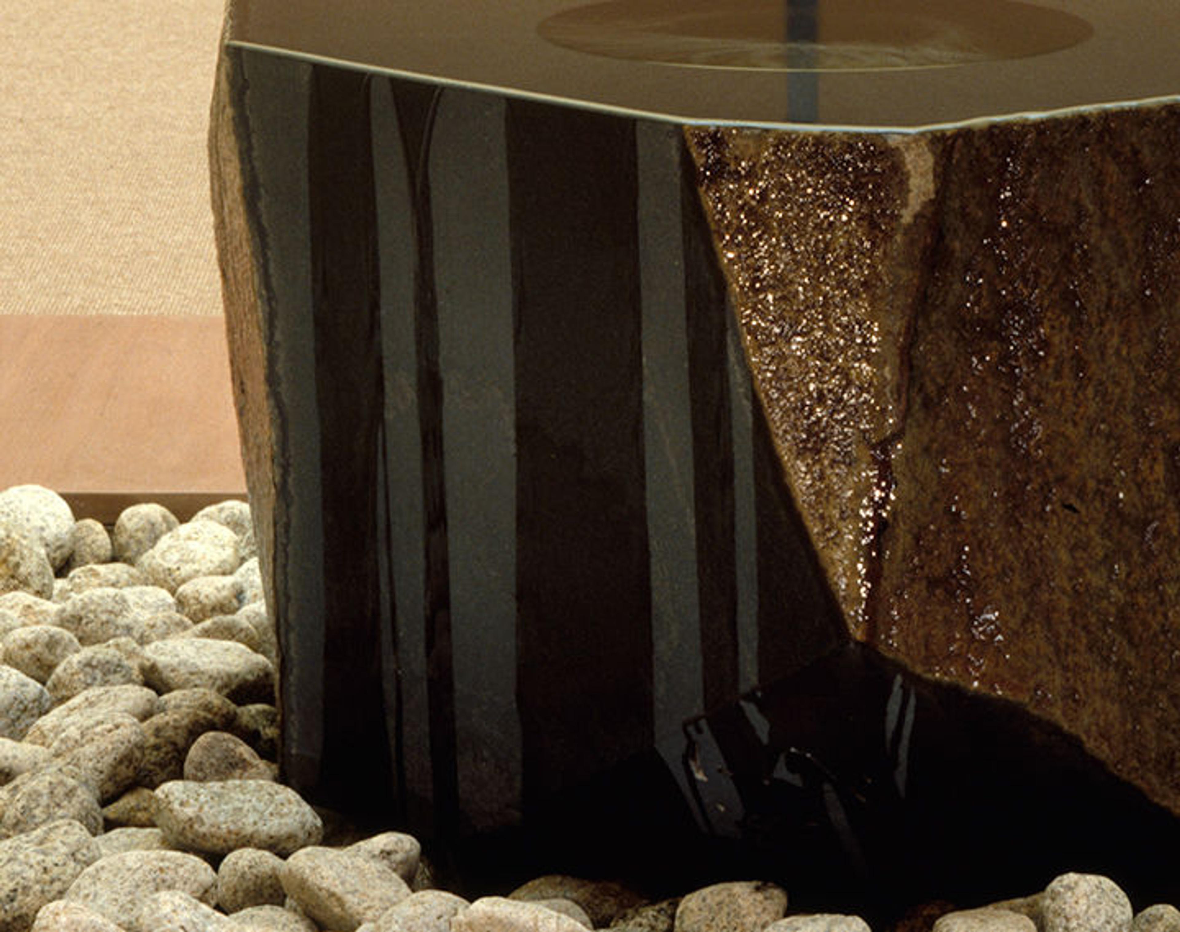 Detail of Isamu Noguchi's Water Stone showing the bottom of the fountain sitting on a bed of river stones.
