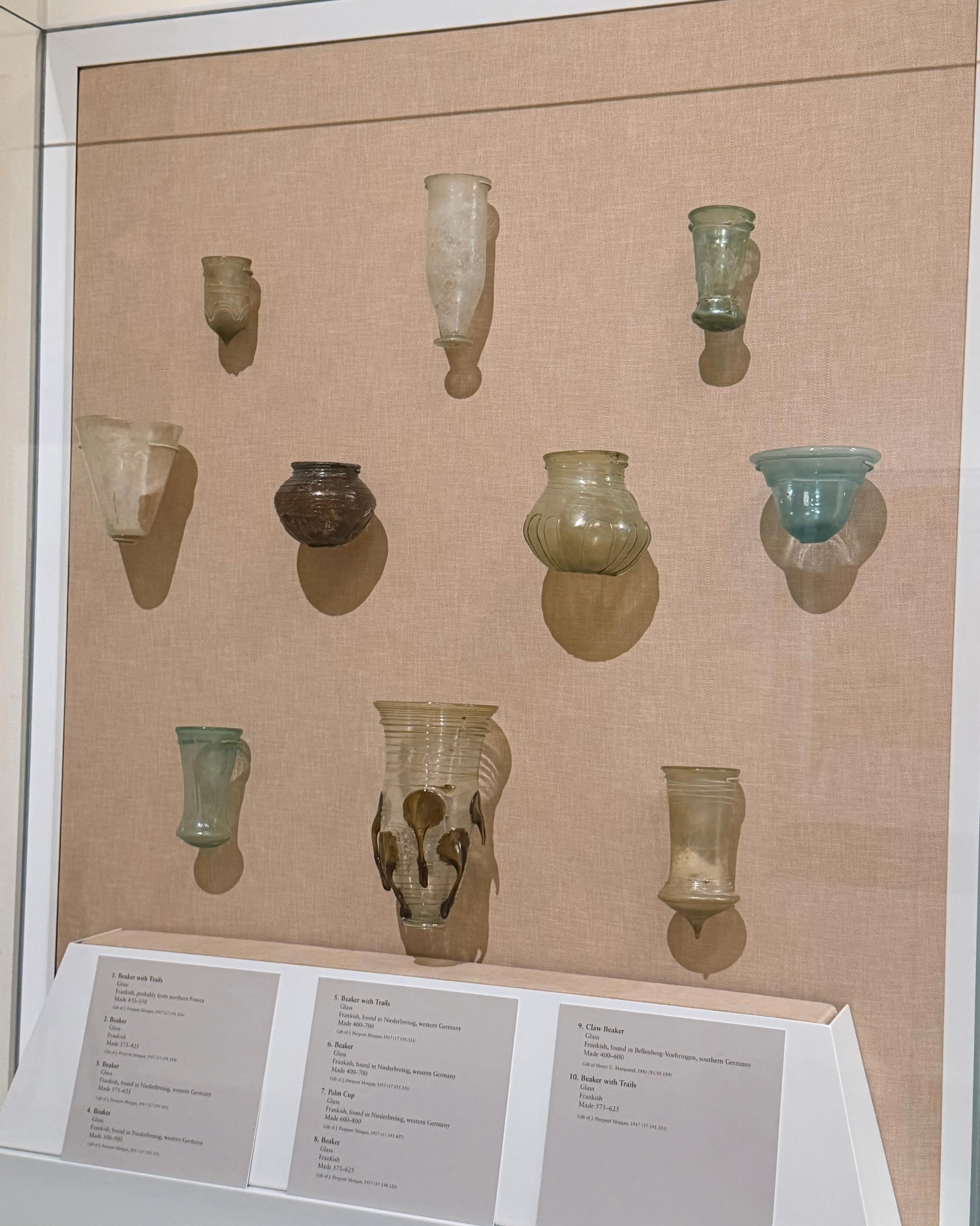A display case exhibits small, multicolored glass vessels