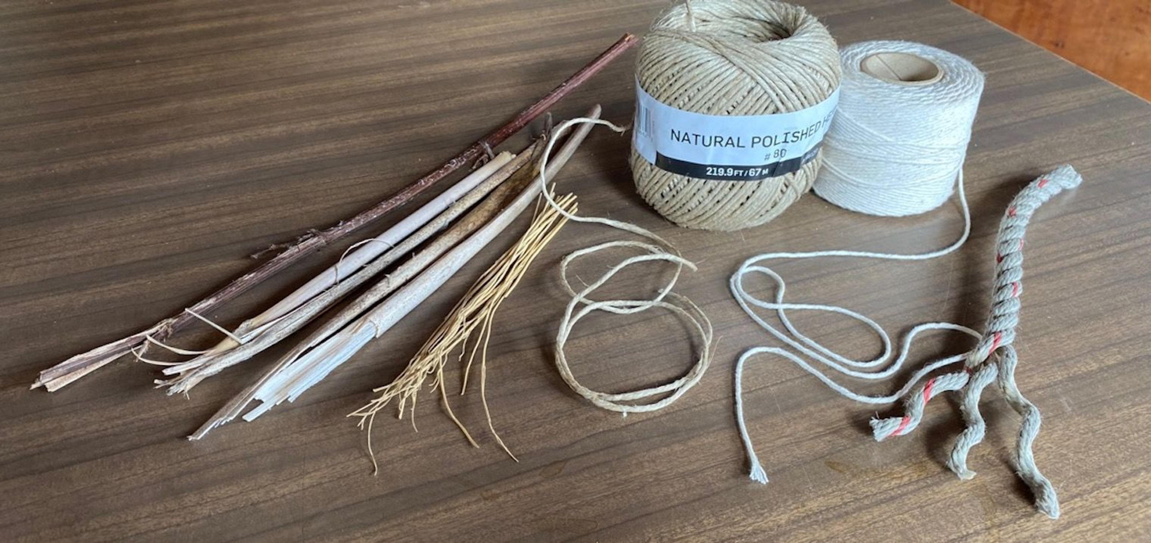 A photograph of twine and some small tree branches spread across a table or workbench.