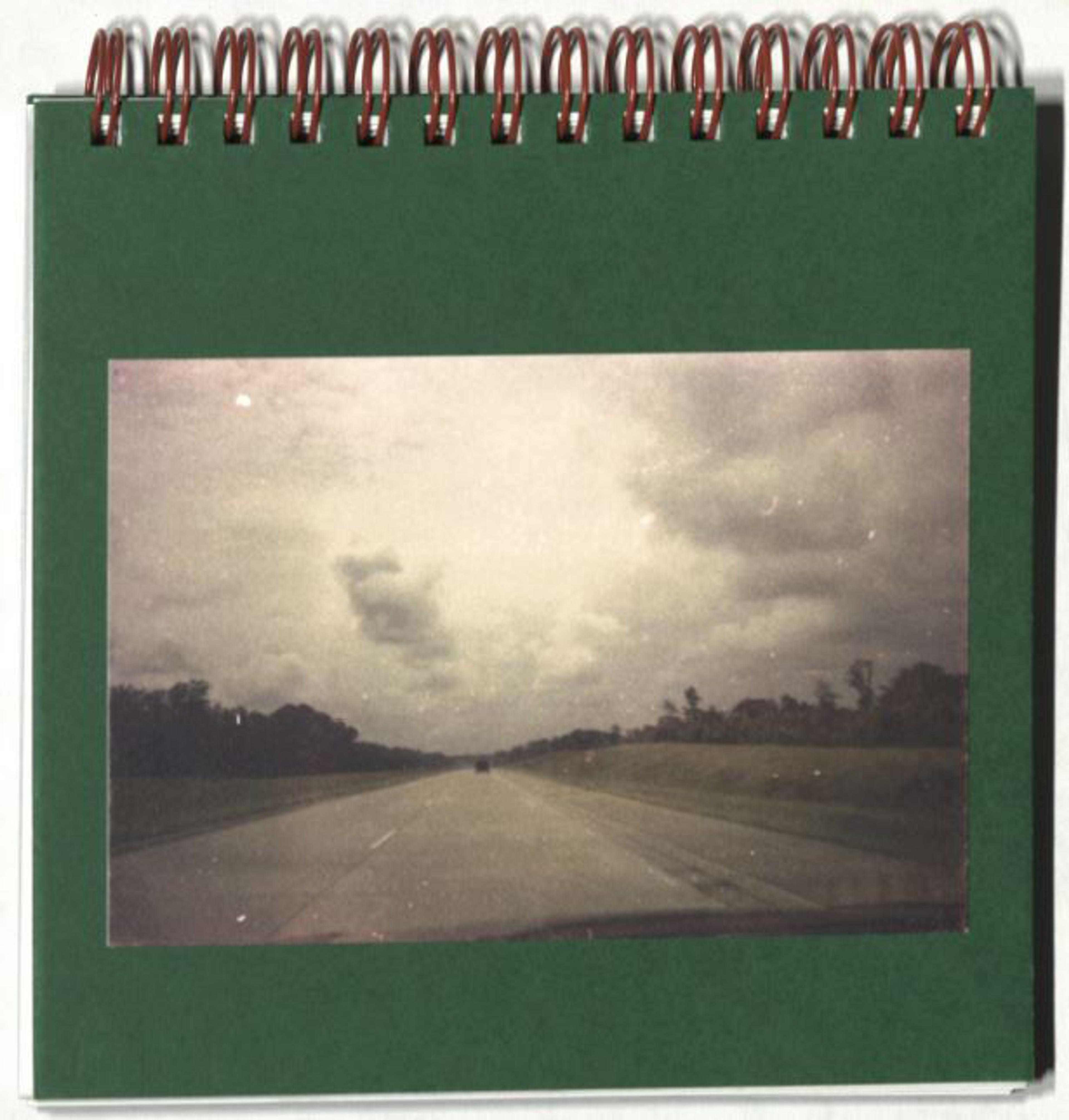 Black and white photo of an open road and clouds