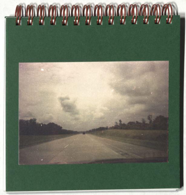 Black and white photo of an open road and clouds