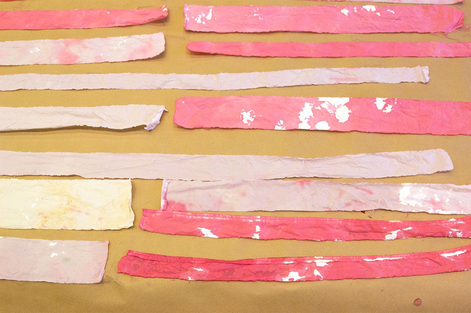 Teens dyed strips of muslin with pink and orange dye made from fruits and vegetables.
