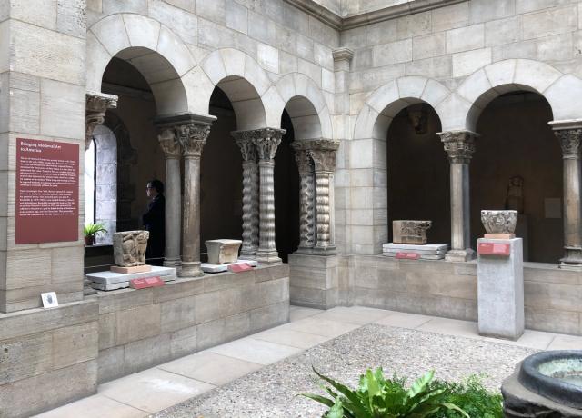 Interior cloister patio with block carvings arranged between pilasters.