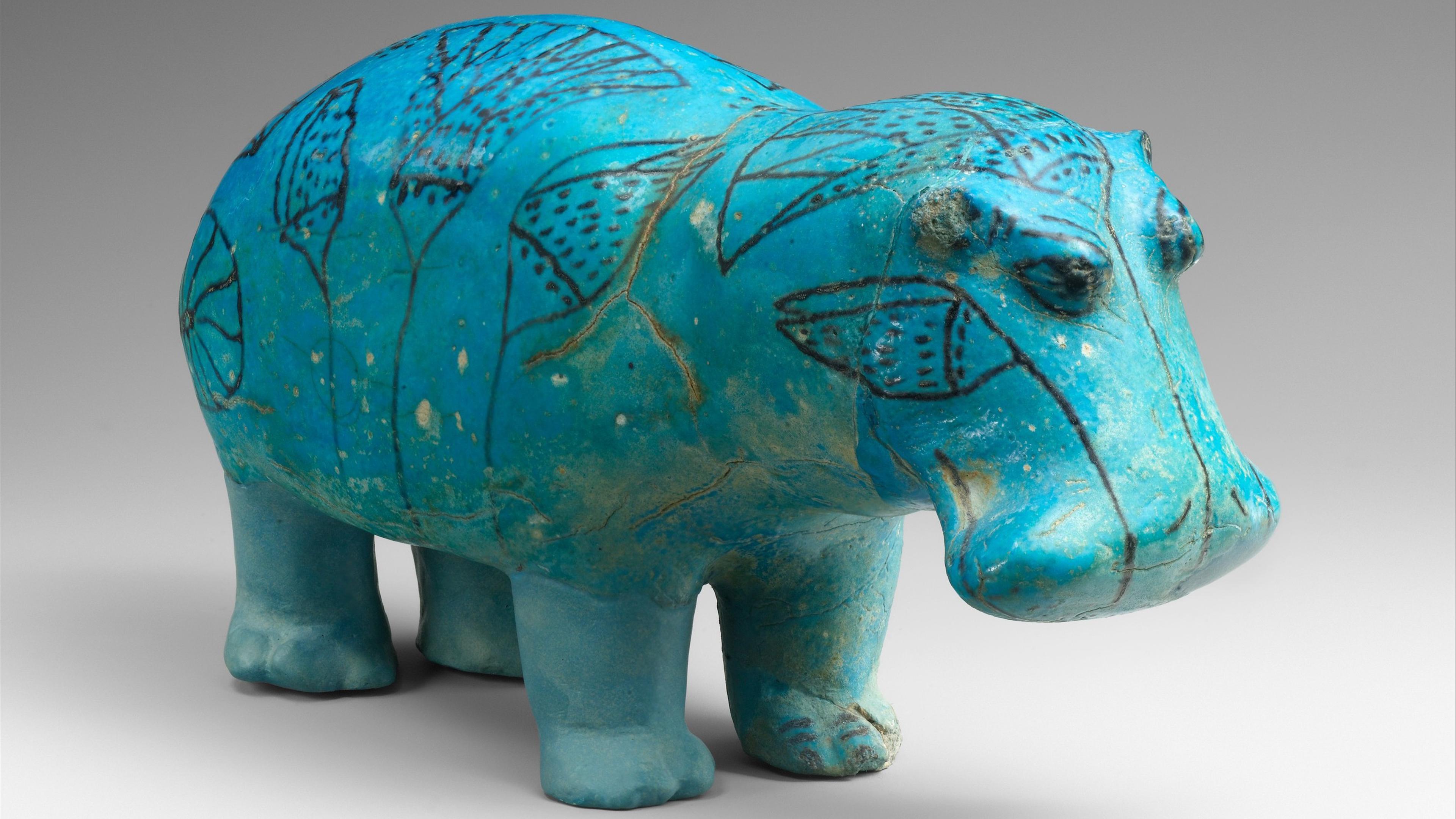 Faience hippopotamus figurine in vibrant turquoise with intricate patterns of leaves over the body and head.