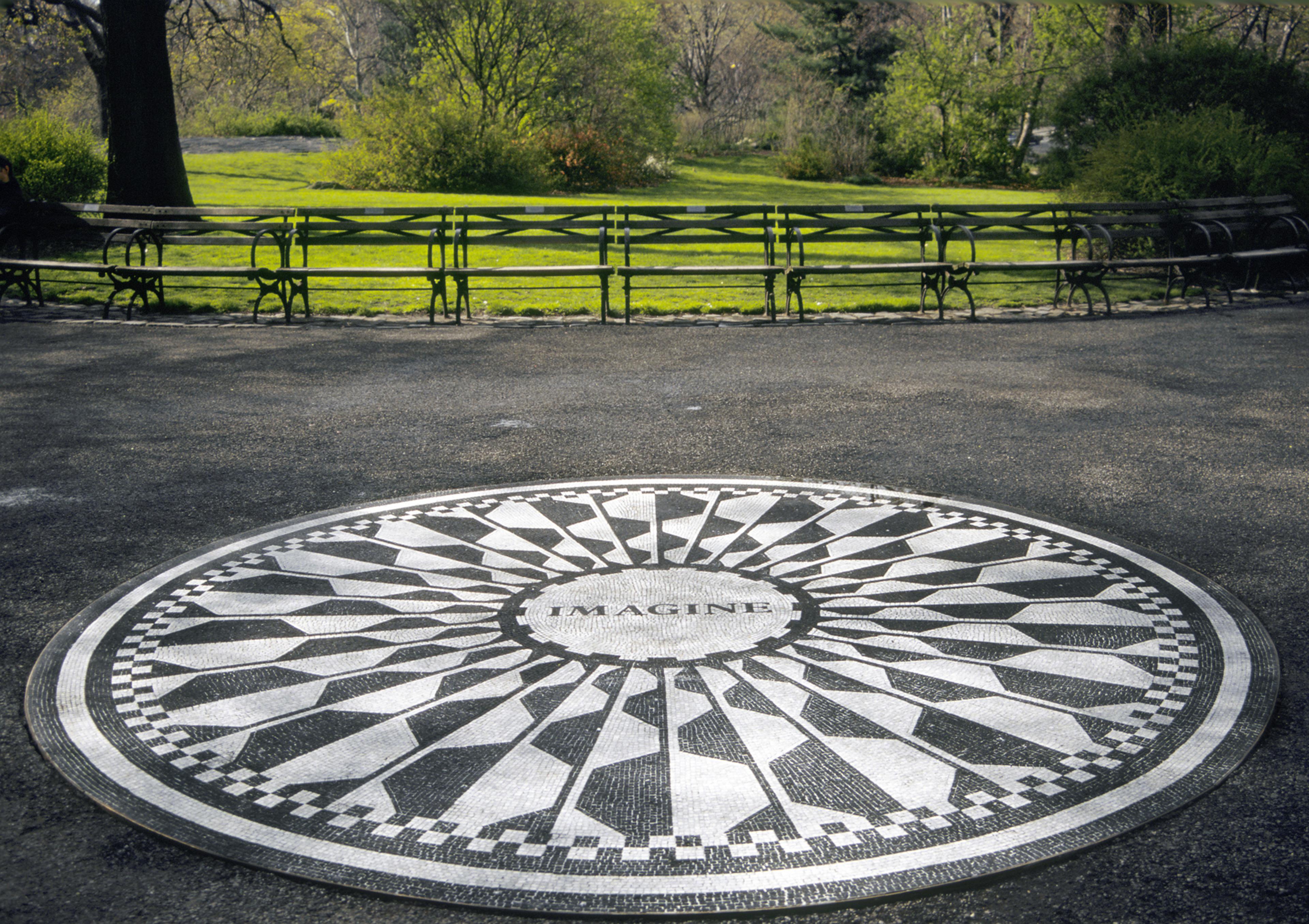 A black and white circular mosaic featuring a geometric pattern with "IMAGINE" at the center