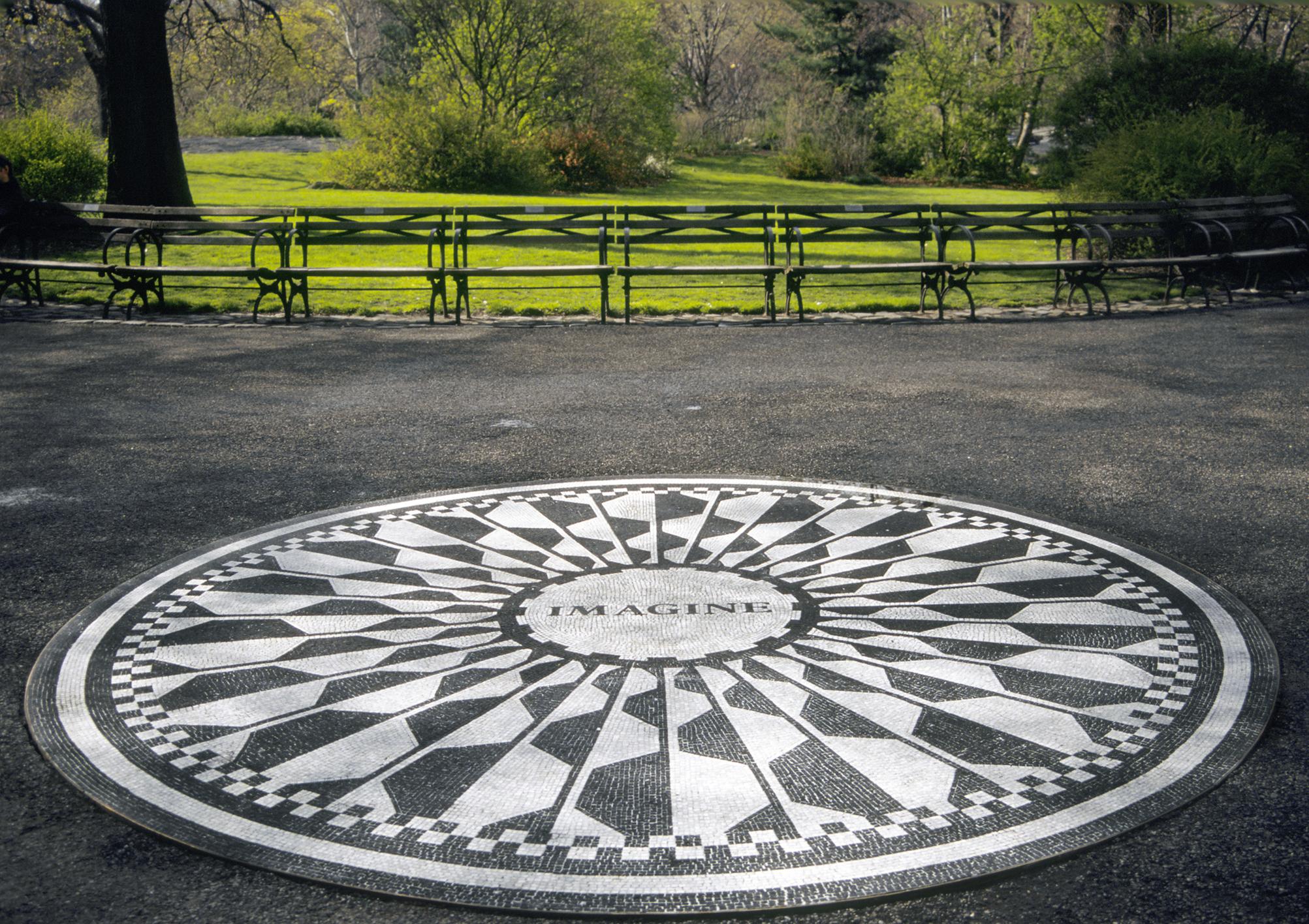 A black and white circular mosaic featuring a geometric pattern with "IMAGINE" at the center