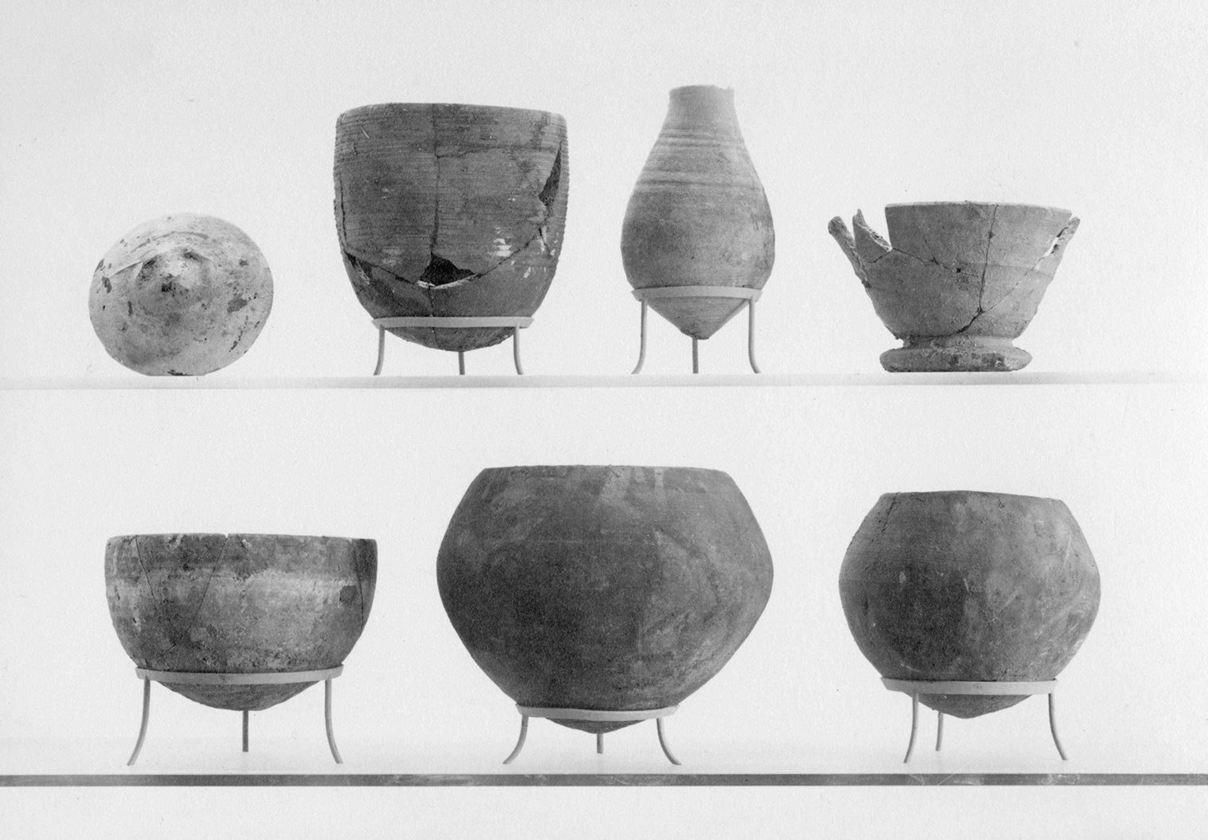 Black and white photograph of seven pottery jars and bowls of various sizes and shapes