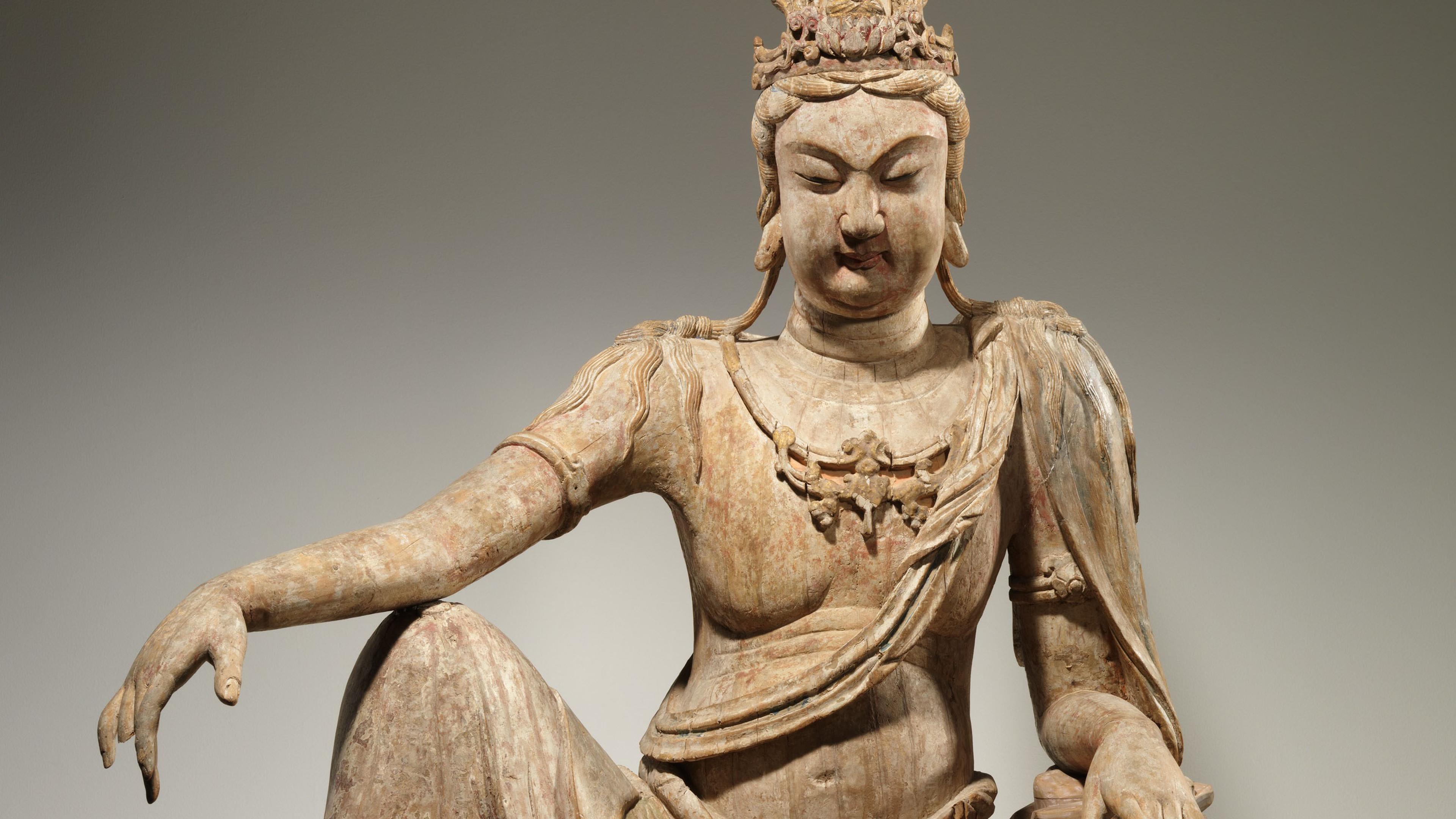 Wooden sculpture of a seated bodhisattva.