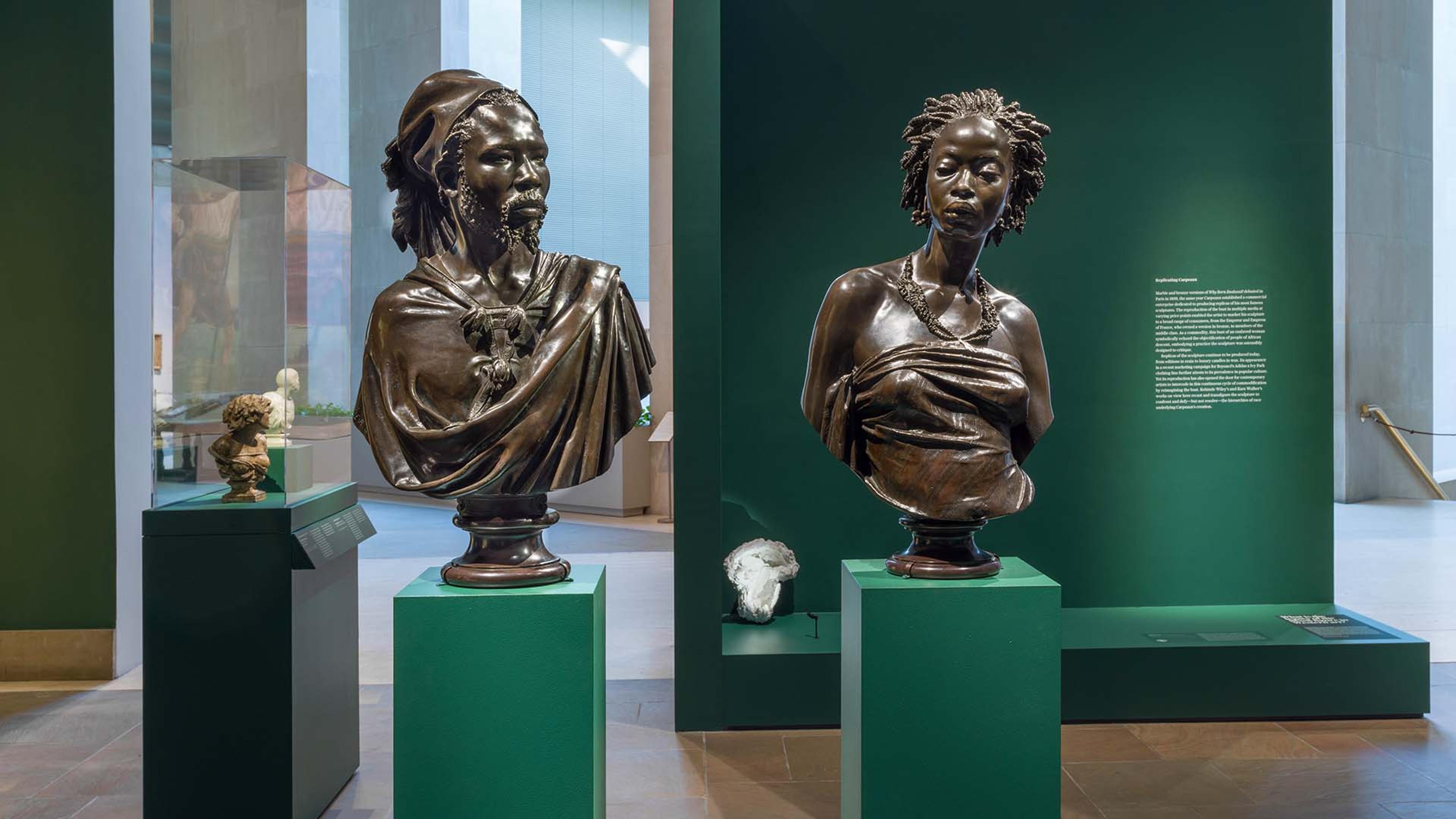 Two statues on green pedestals