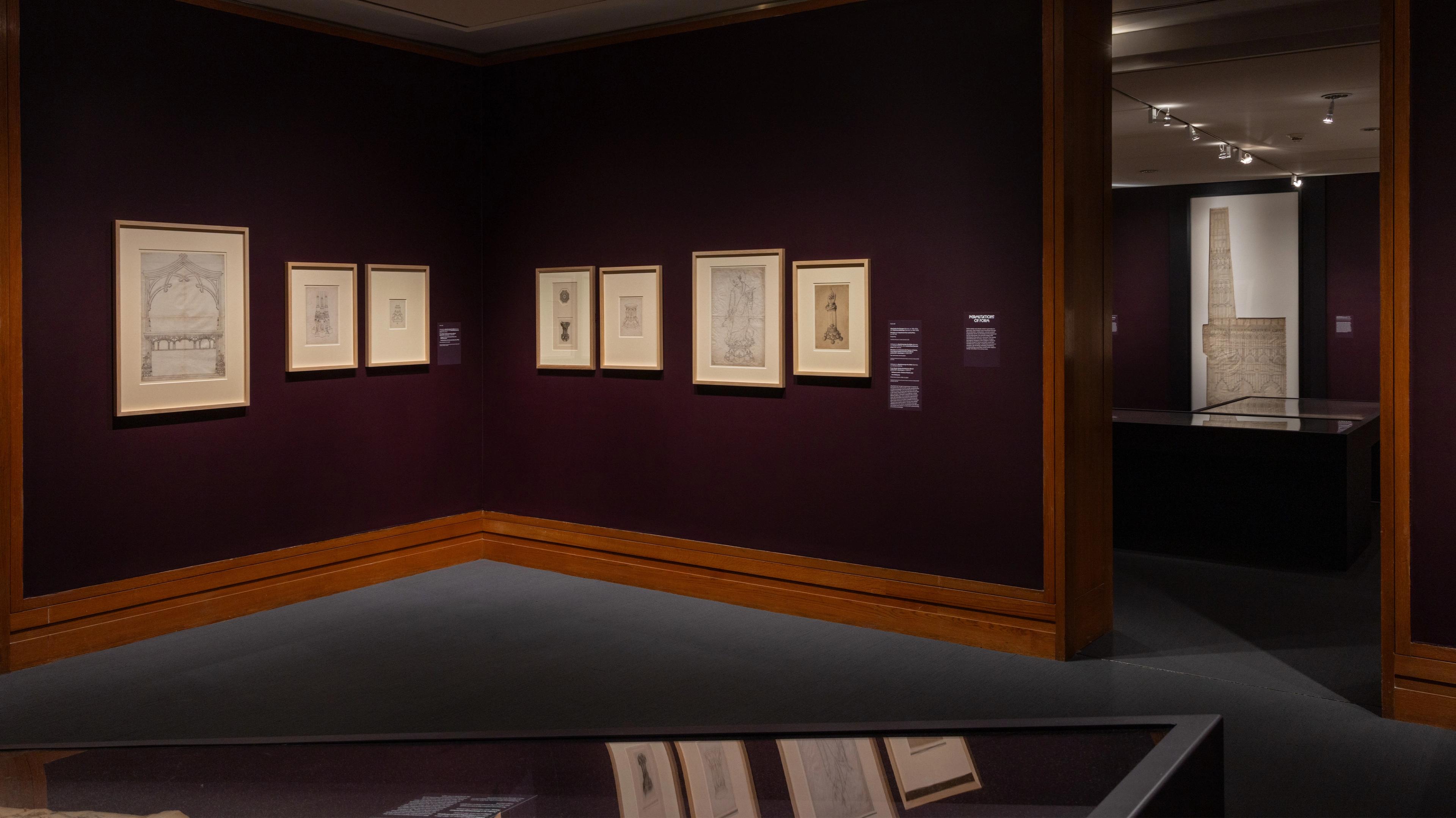 Art gallery corner with dim lighting, featuring framed sketches on deep purple walls.