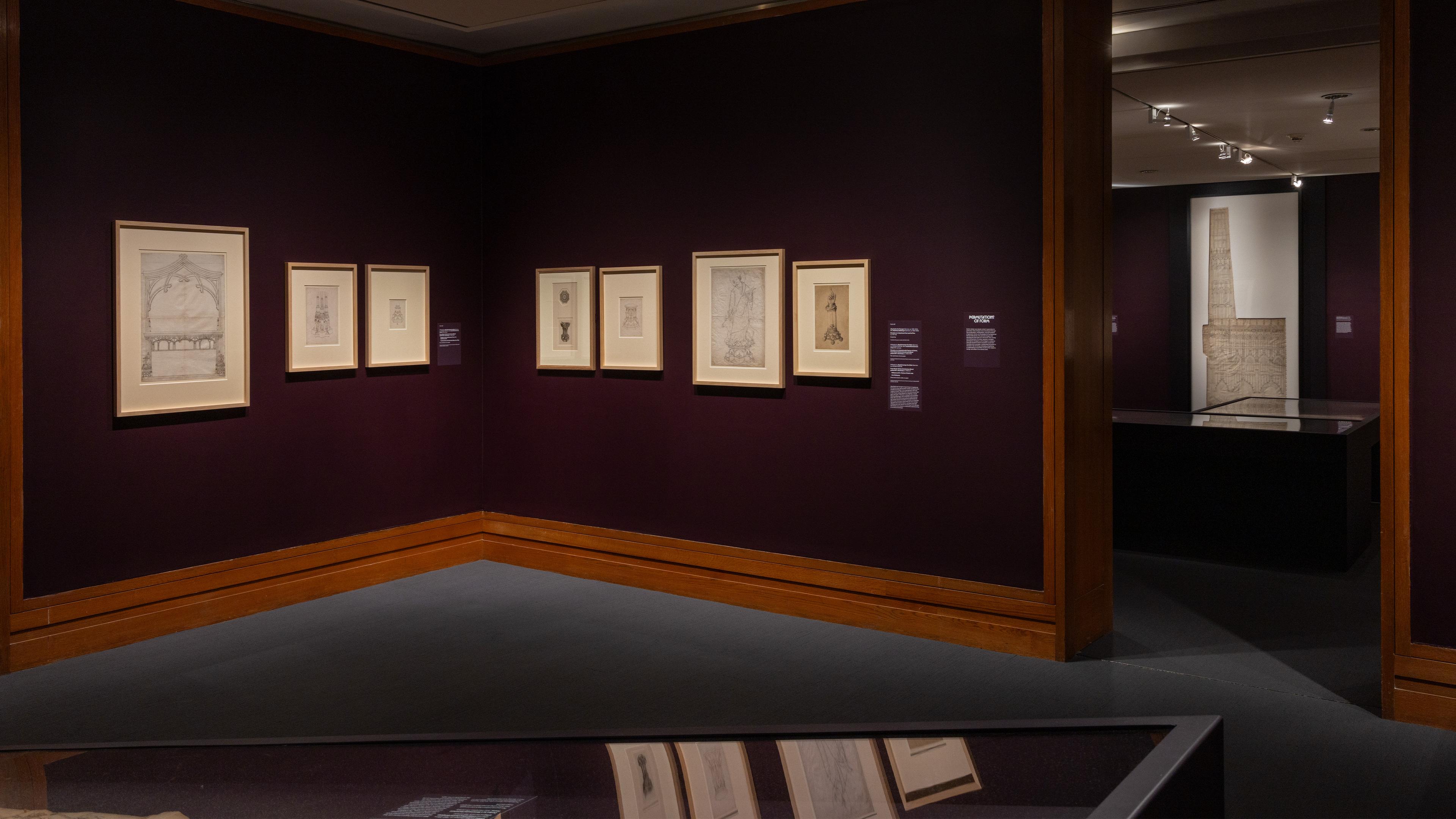 Art gallery corner with dim lighting, featuring framed sketches on deep purple walls.
