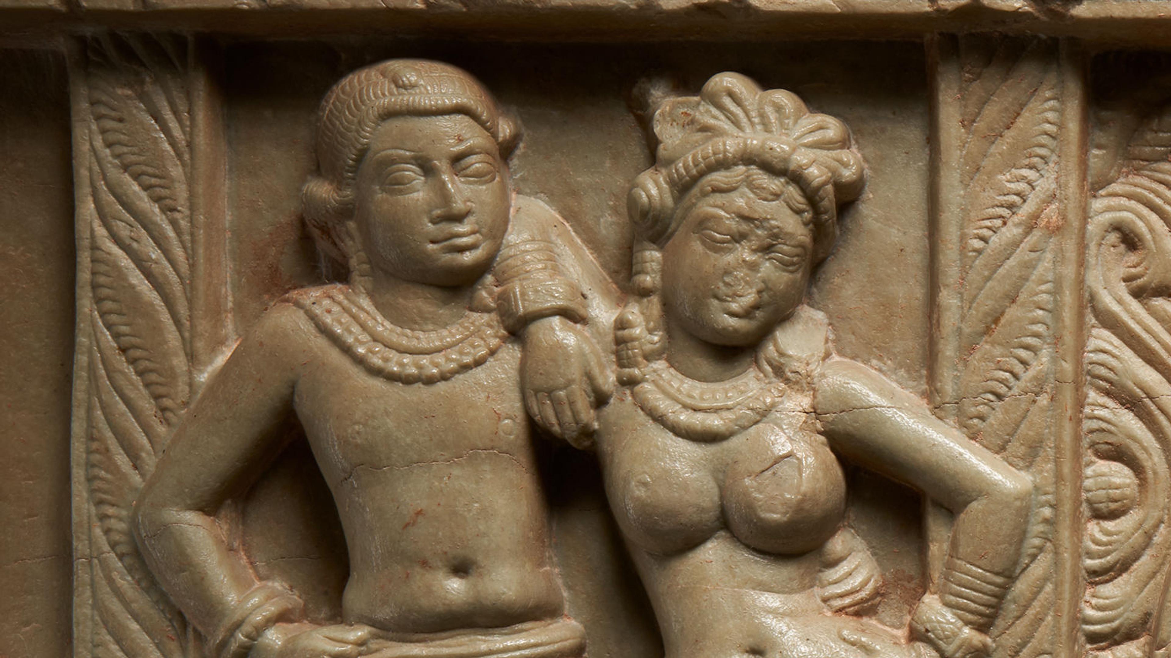 Limestone carving of a male and female figure