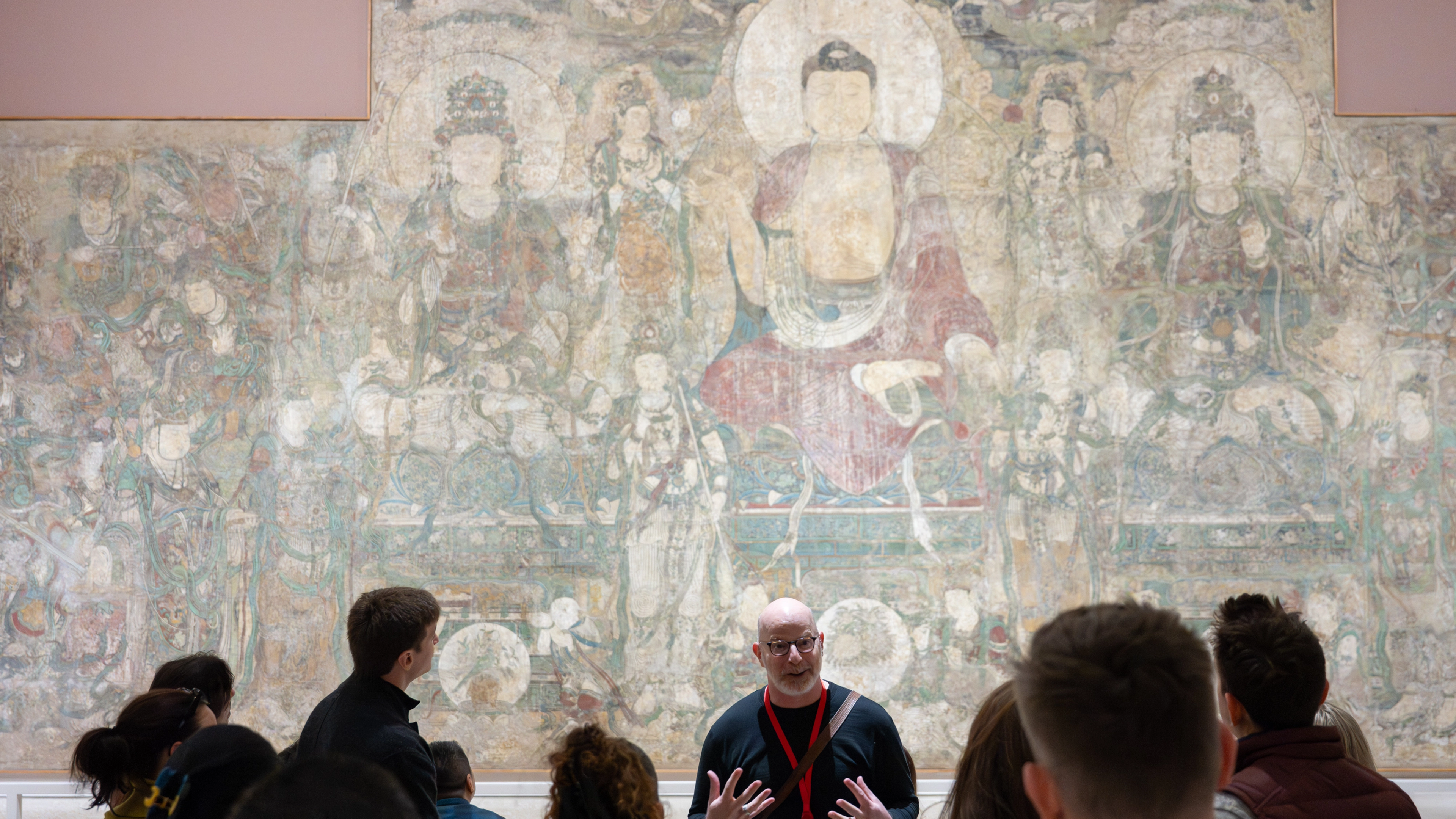 A tour guide and group in front of the Buddha of Medicine Bhaishajyaguru (Yaoshi fo)