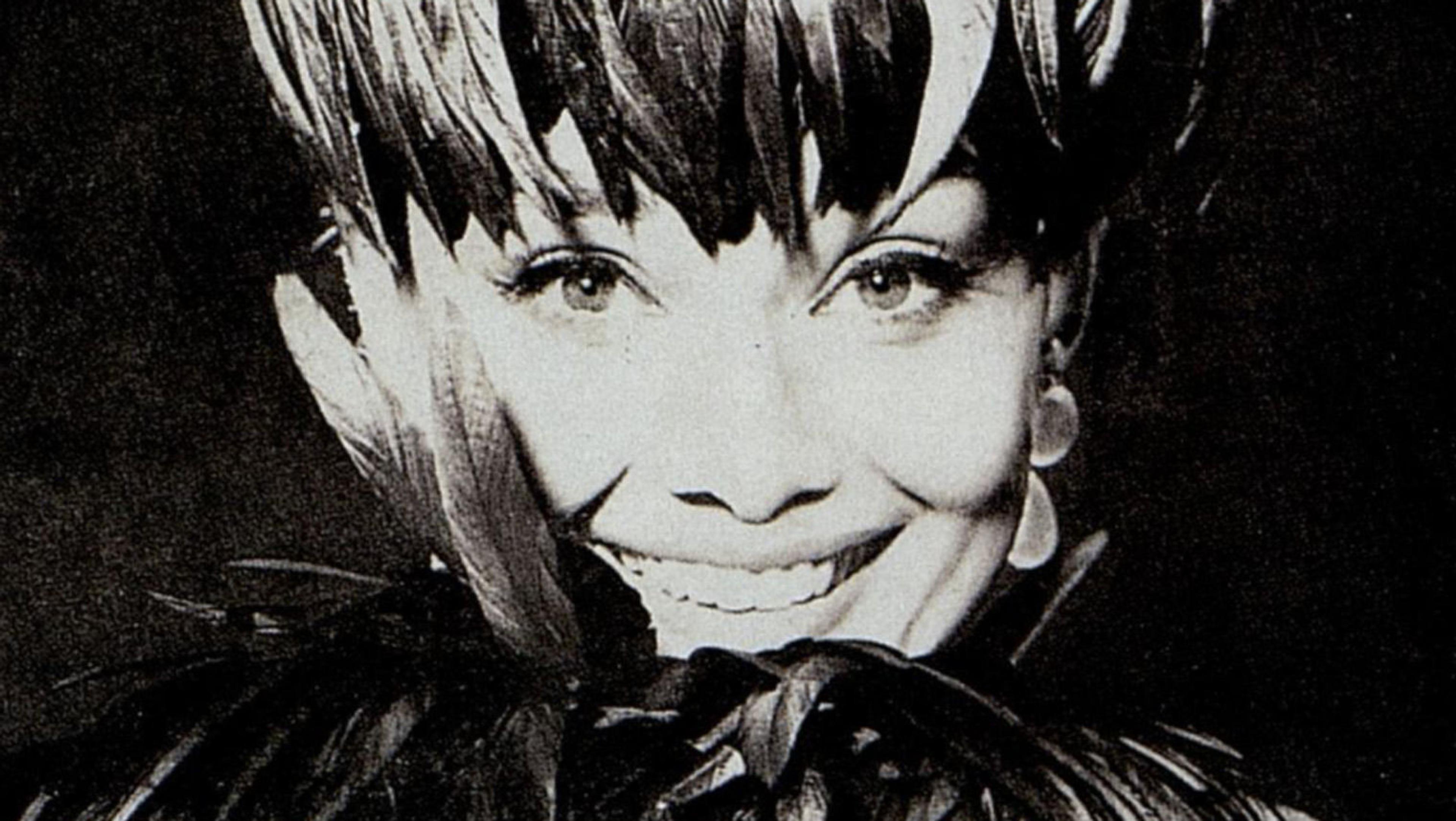 Black-and-white headshot of Audrey Hepburn in a feathered hat and ruff