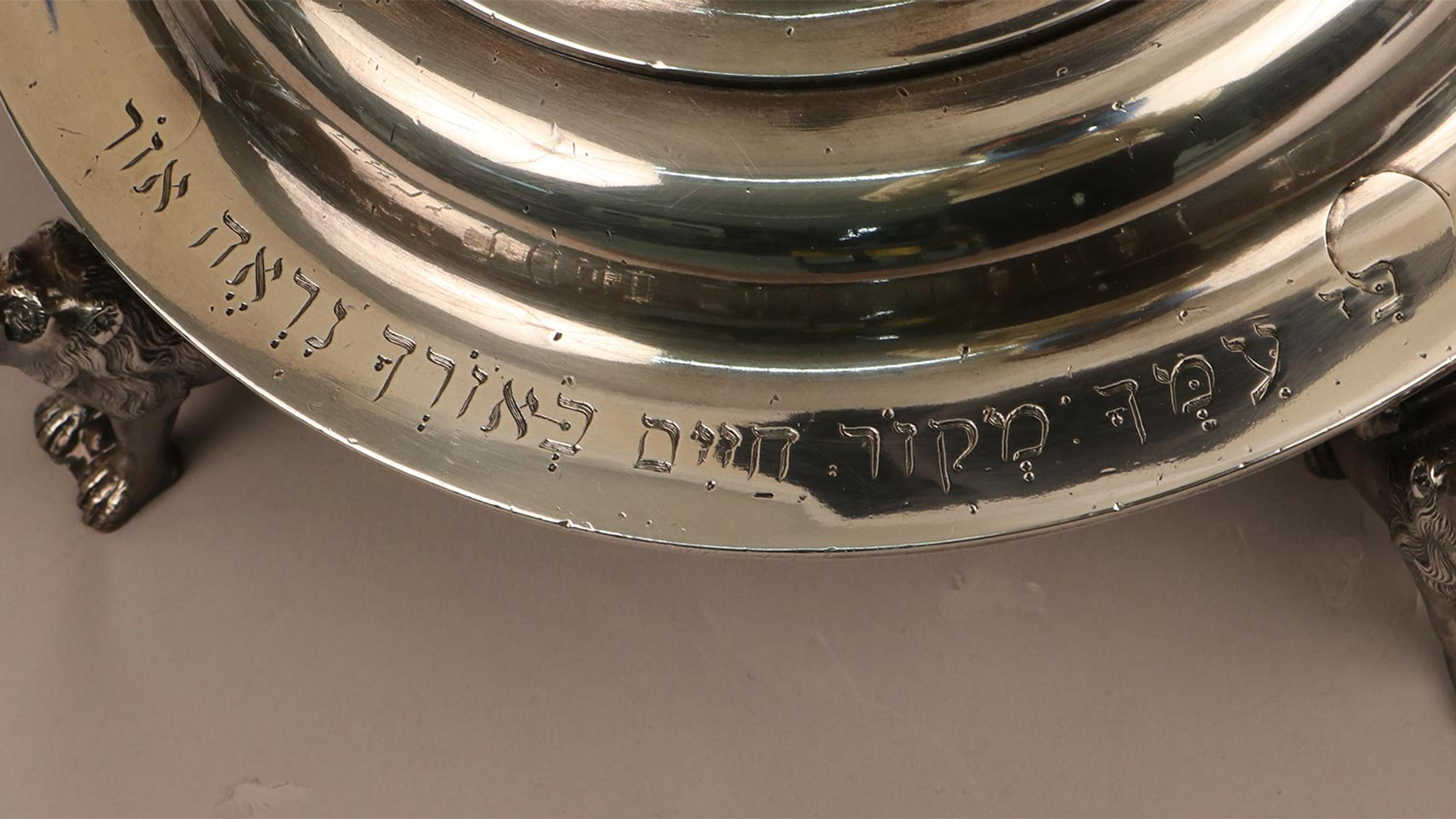 An inscription on the base of a silver lamp