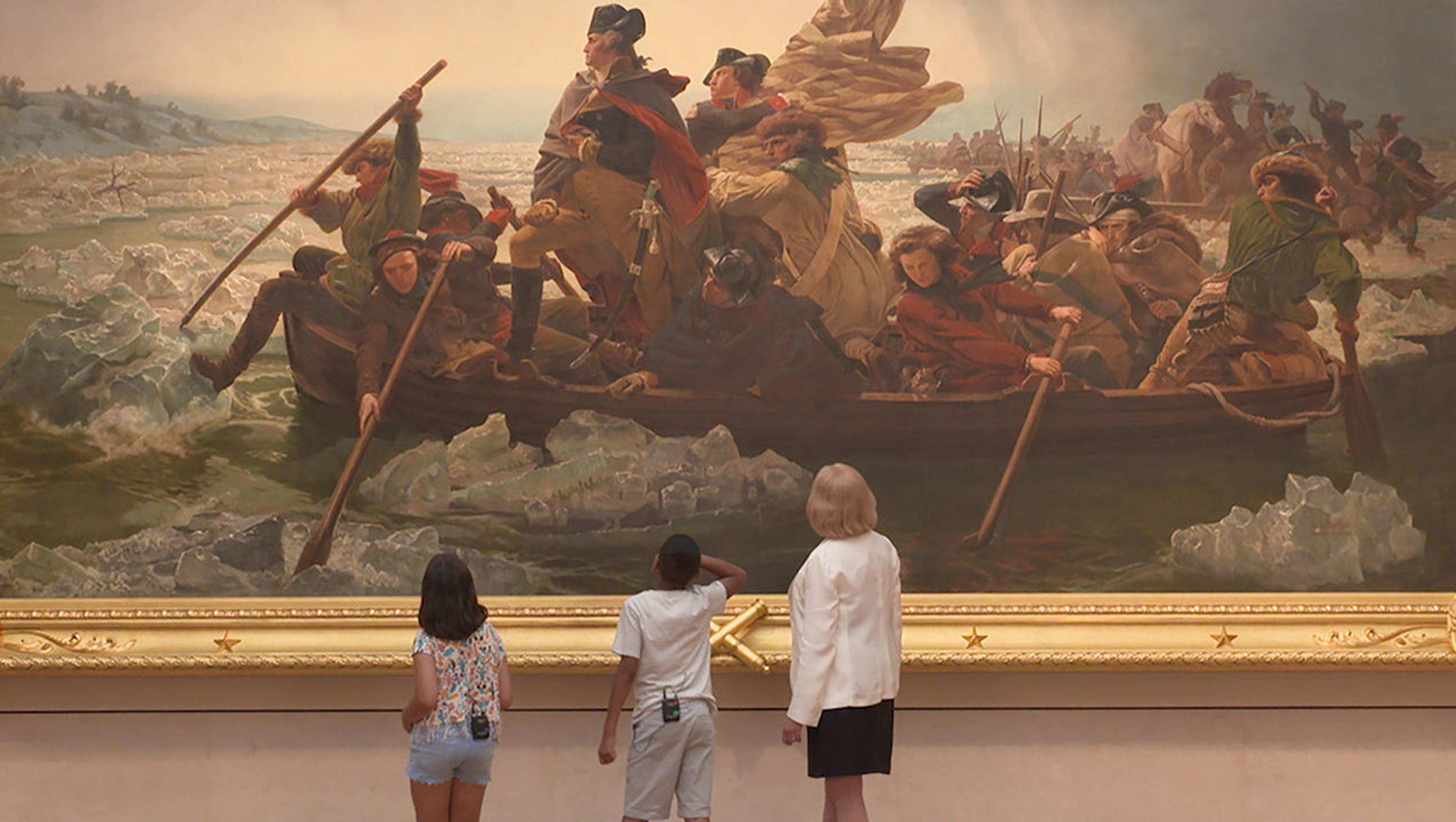 Adult curator Betsy Kornhauser and two kids named Gaia and Carmelo look at the painting Washington Crossing the Delaware at The Met. Their small figures are dwarfed by the large painting.
