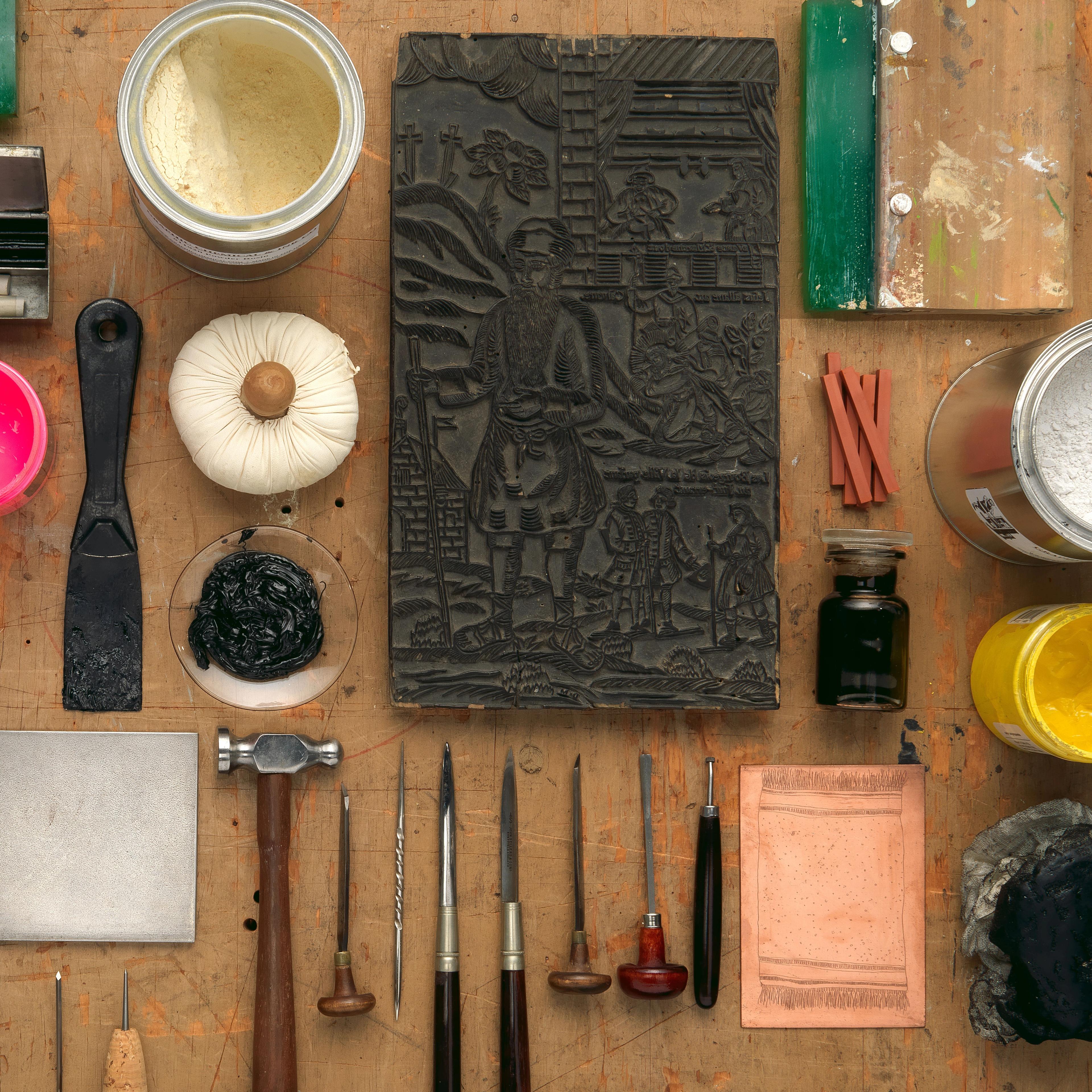 An artful arrangement of printmaking tools laid out on a table.