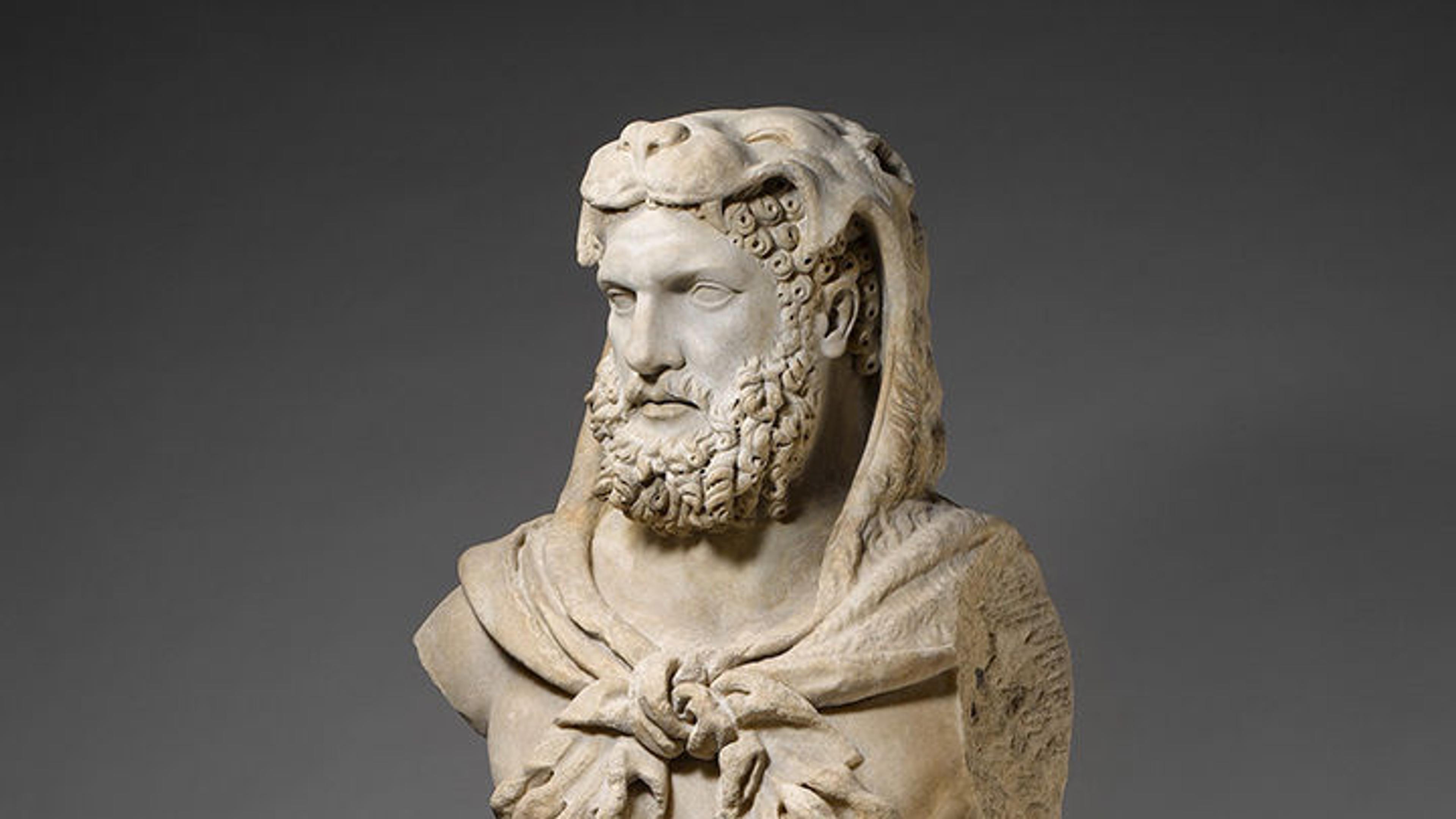 Roman statue of Hercules with a lion carcass draped over his head, paws wrapped across his chest.