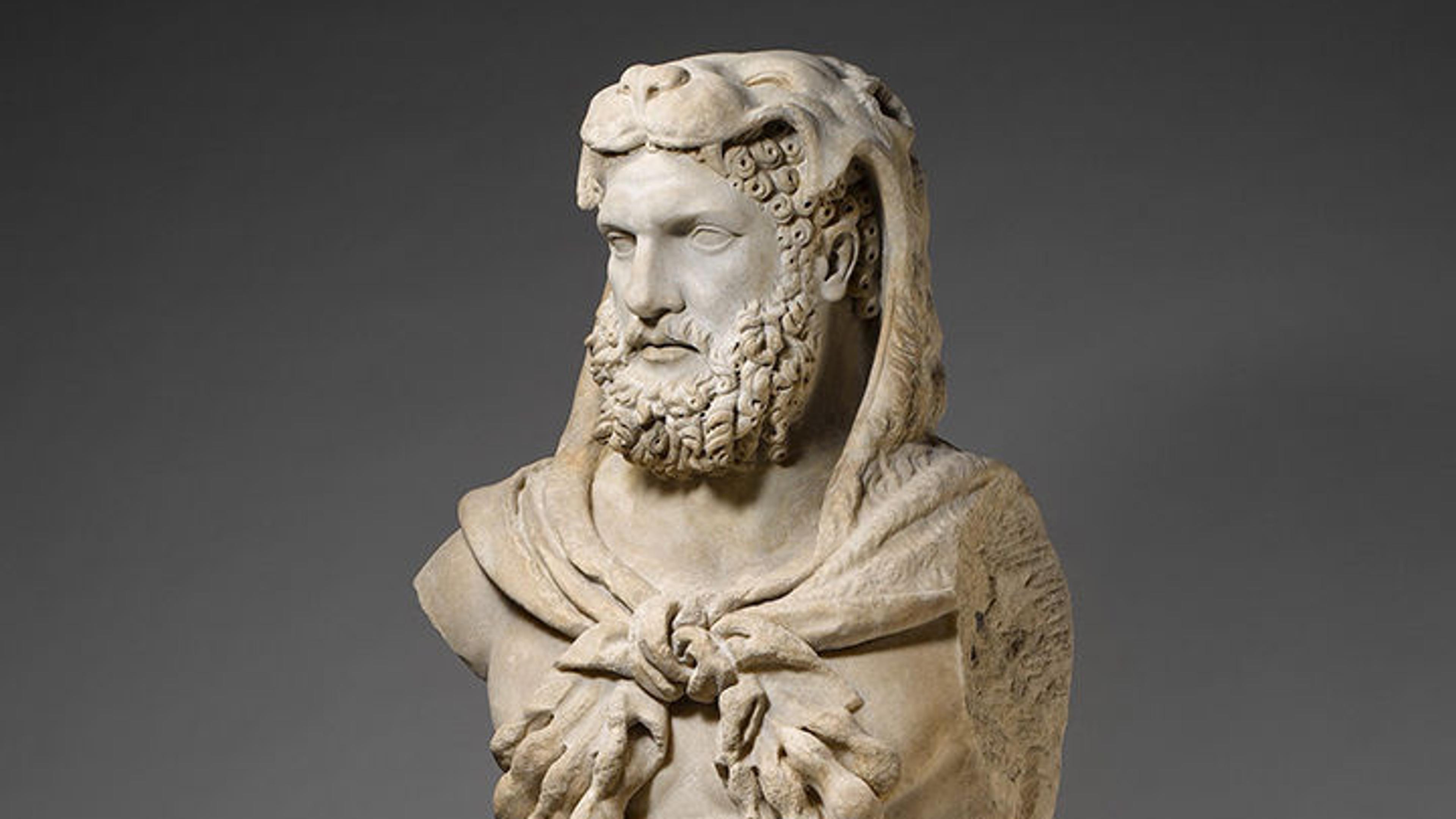 Roman statue of Hercules with a lion carcass draped over his head, paws wrapped across his chest.