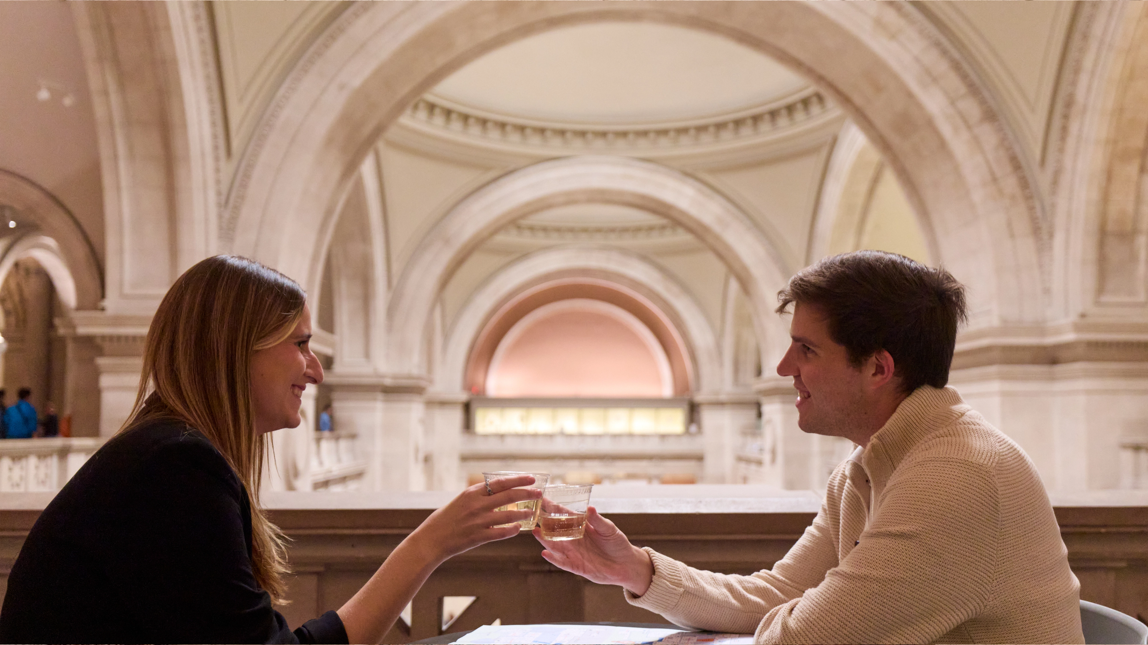 People clink glasses at The Met's Great Hall Balcony Cafe