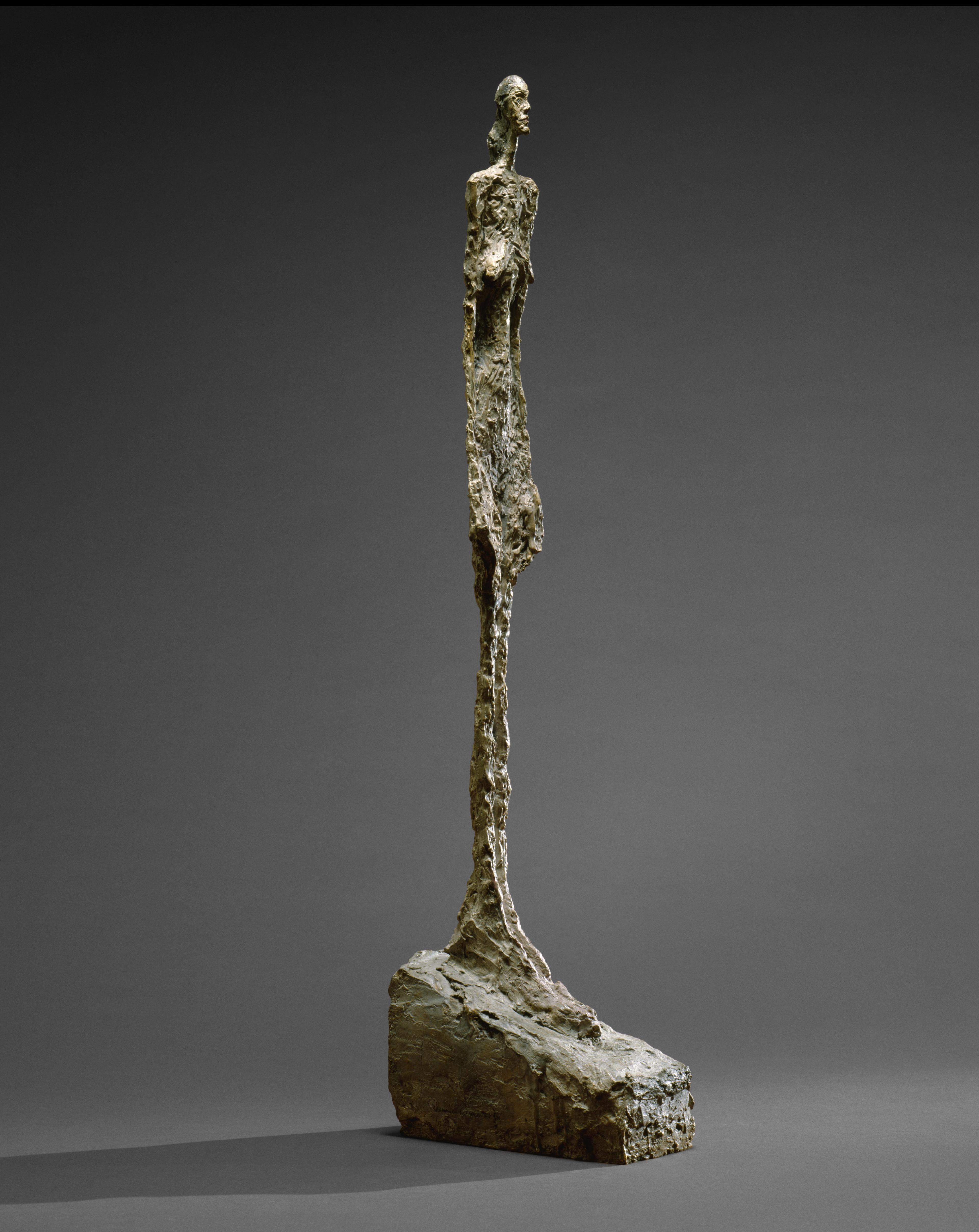 A sculpture of an elongated female figure standing