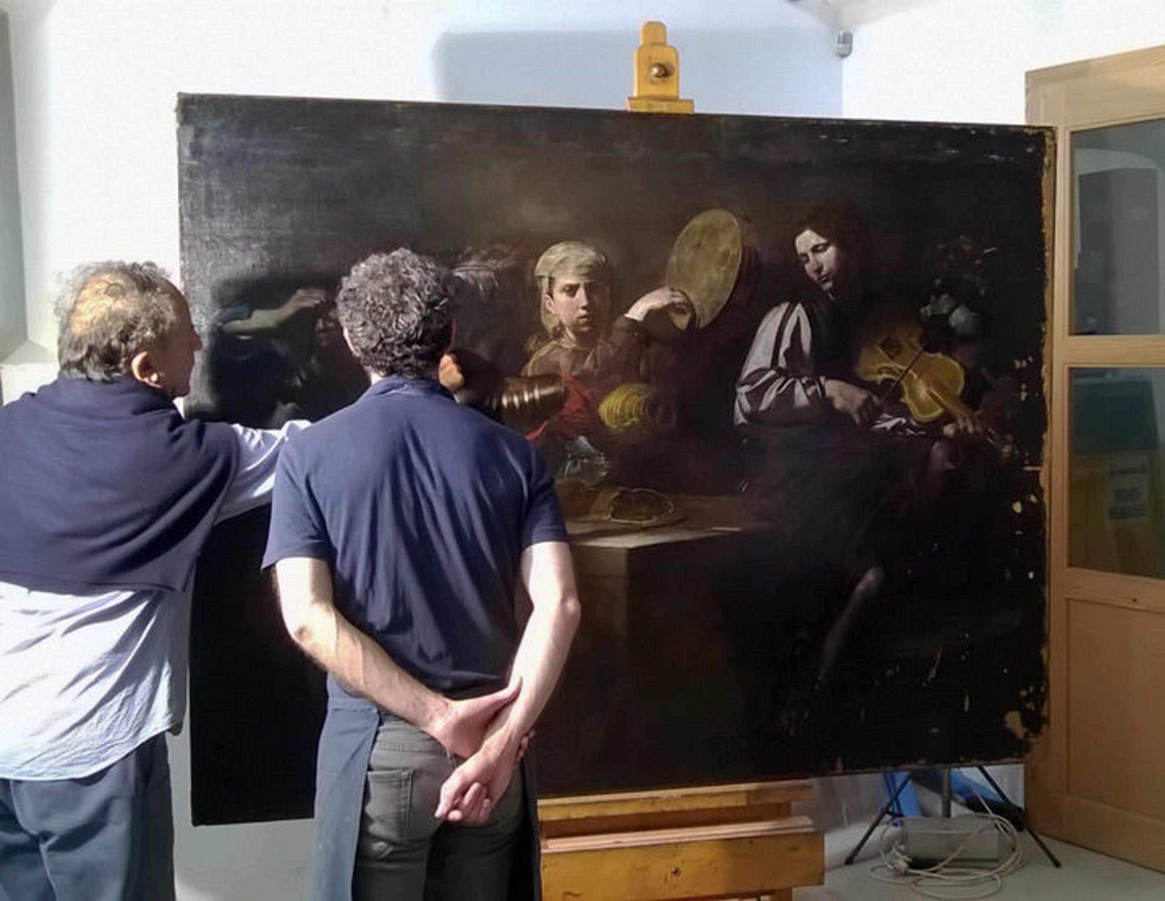 A curator and a conservator discuss a painting by Valentin de Boulogne during the treatment process