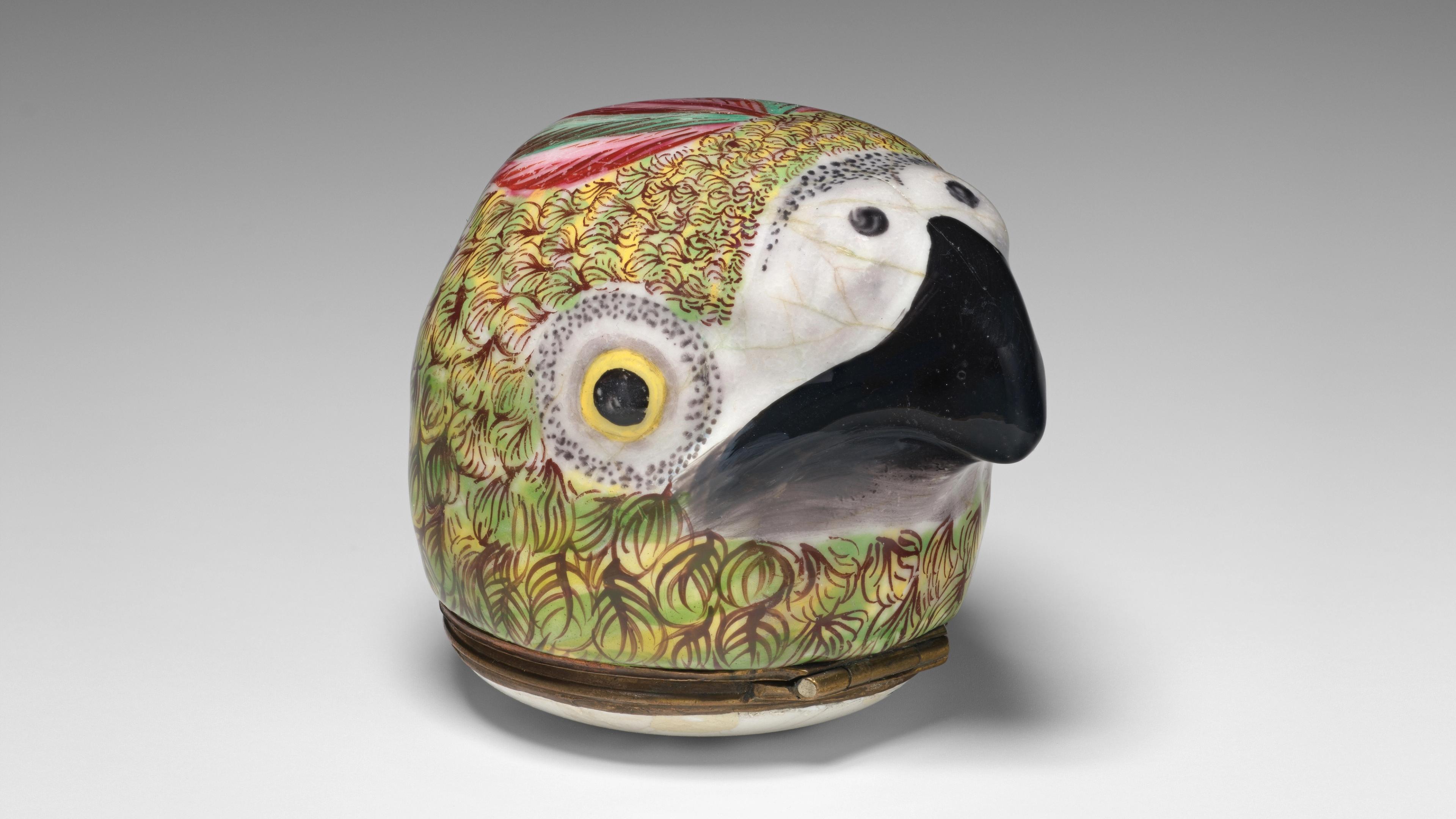 A green, yellow, and pink parrot's head, with a hinge at the base of its neck.