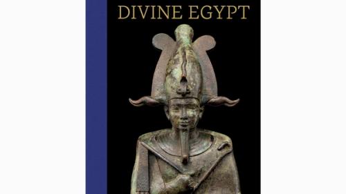 a faded bronze statue of an Egyptian god's head and torso, holding a rod, with an elaborate headdress