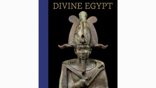 a faded bronze statue of an Egyptian god's head and torso, holding a rod, with an elaborate headdress